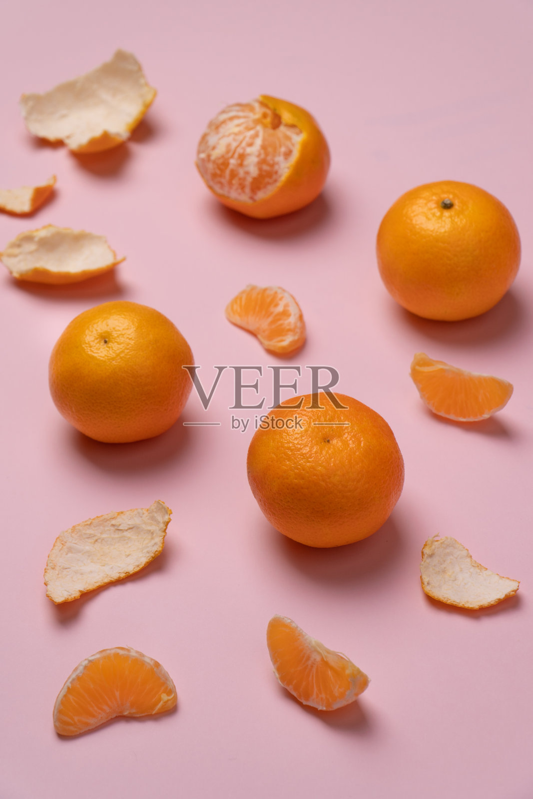 在粉红色的表面上垂直拍摄新鲜的橘子照片摄影图片