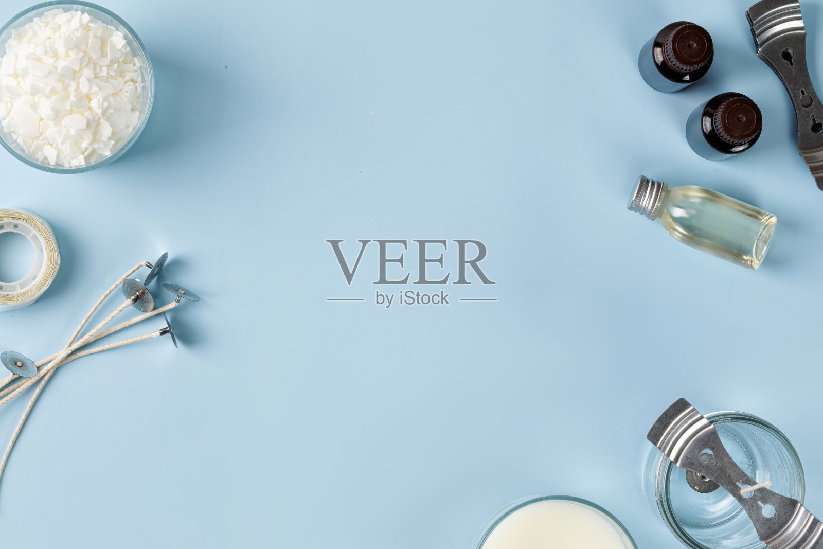 蜡烛制作工具和设备。罐装有灯芯,椰子或有机大豆蜡,香味。Flatlay顶视图。副本的空间。蓝色背景照片摄影图片