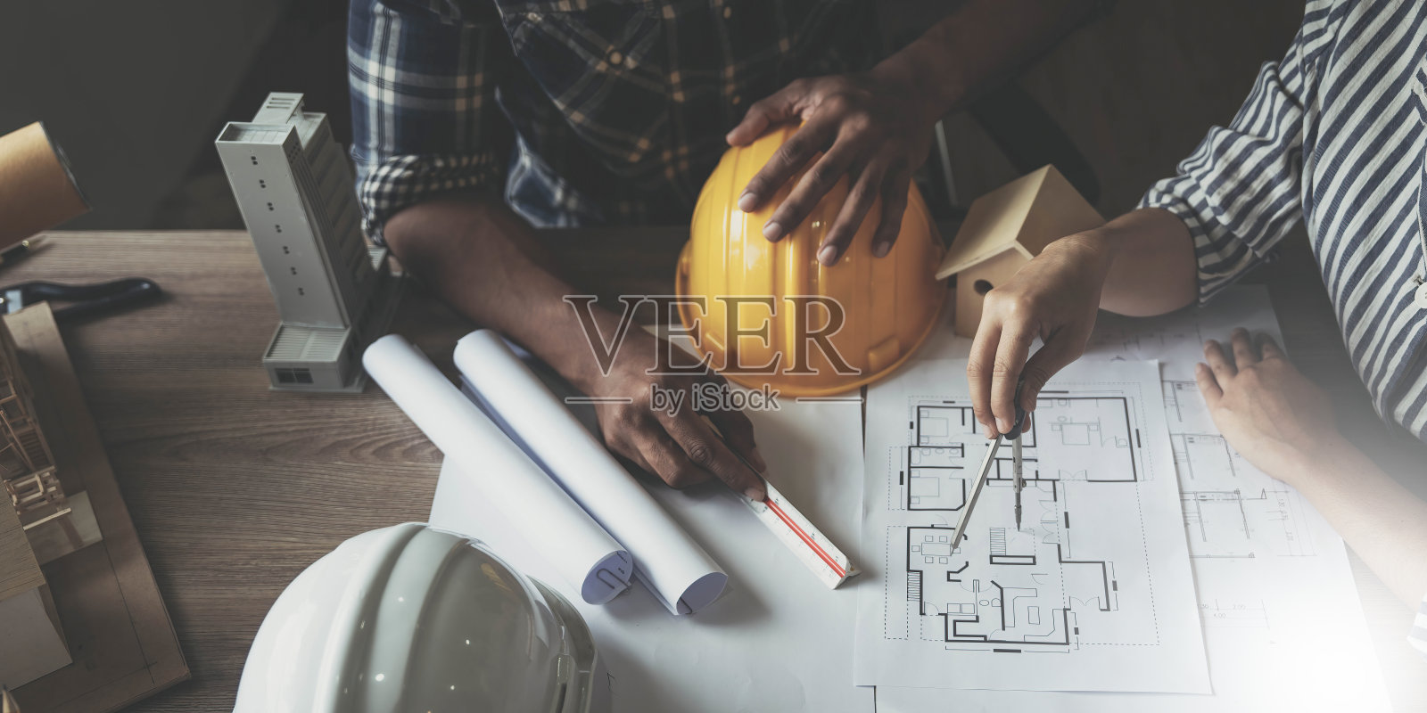 建筑商两个年轻的亚洲工程师和一个女建筑师正在讨论在现场建造一个工业工厂的计划。工人的概念。照片摄影图片