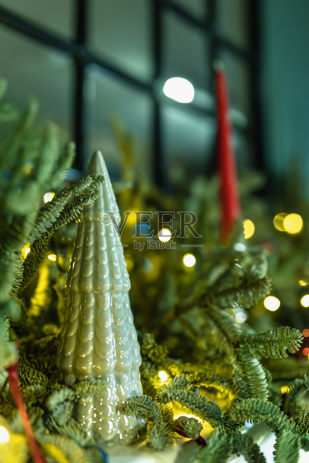 由杉树树枝、瓷雕像和蜡烛组成。照片摄影图片