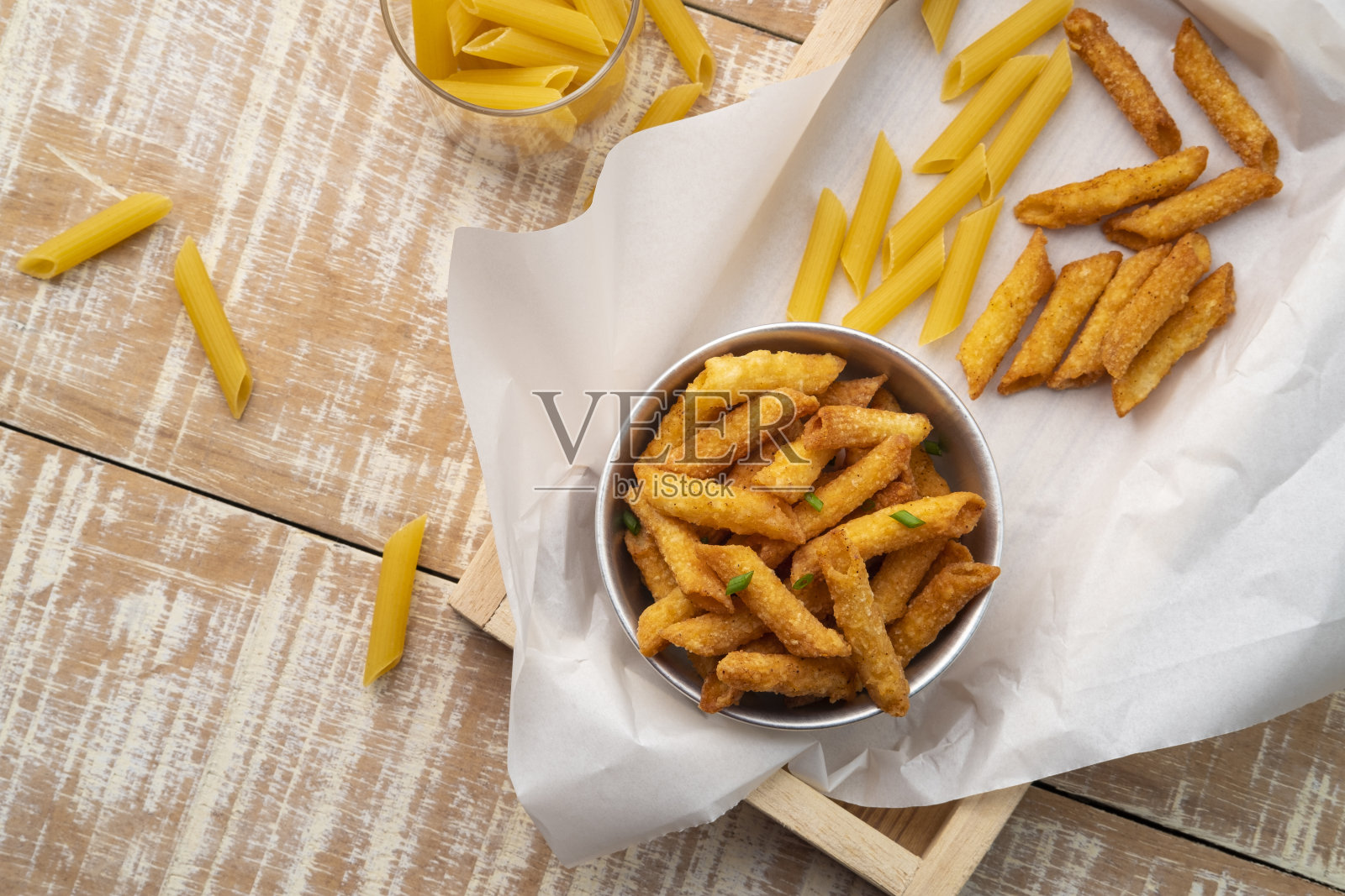 脆皮通心面小吃,将通心粉煮熟,裹上香料,放入碗中炸至酥脆照片摄影图片