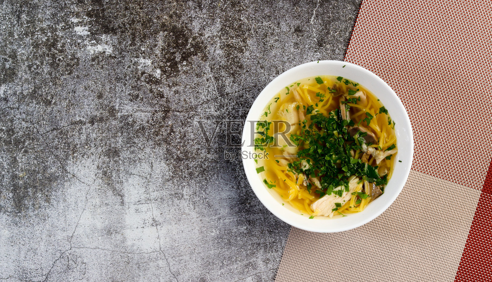 鸡肉汤面和香草在一个黑暗的背景下碗。俯视图,平铺照片摄影图片