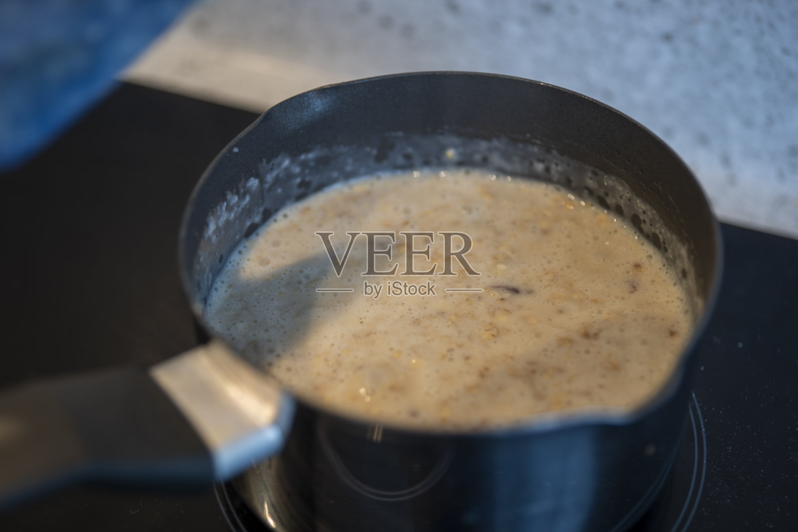 在电磁炉上煮粥和葡萄干照片摄影图片