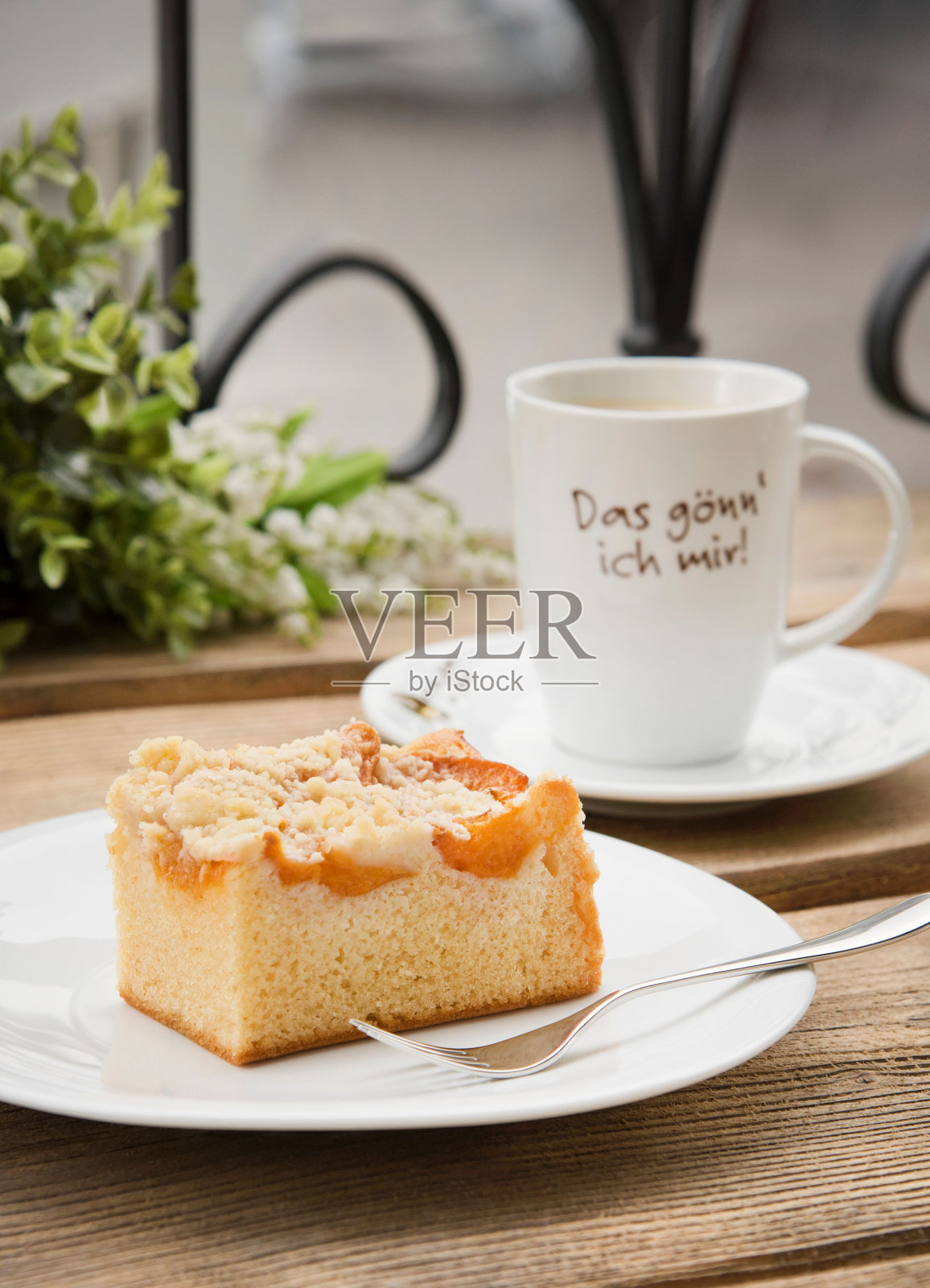 垂直的苹果蛋糕放在一个白色盘子上,背景是一杯咖啡。照片摄影图片