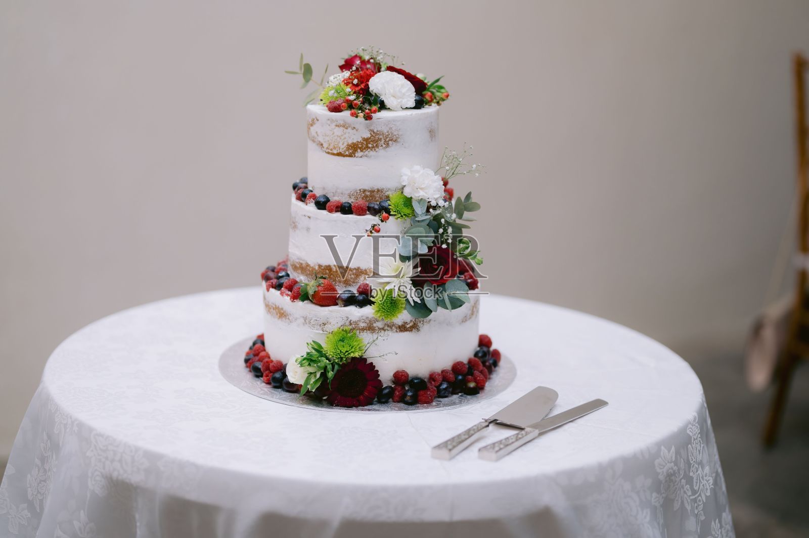 白色的桌子上有浆果的白色蛋糕的特写照片摄影图片