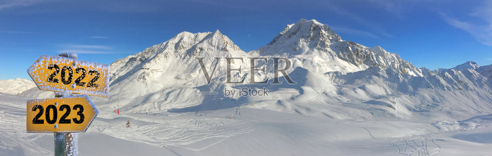 在雪山背景上,用相反方向的黄色箭头写着2022年和2023年照片摄影图片
