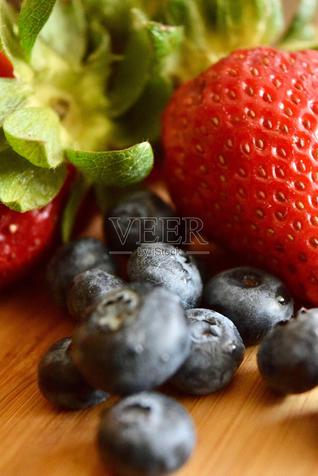 木桌上新鲜可口的蓝莓和草莓的特写照片摄影图片
