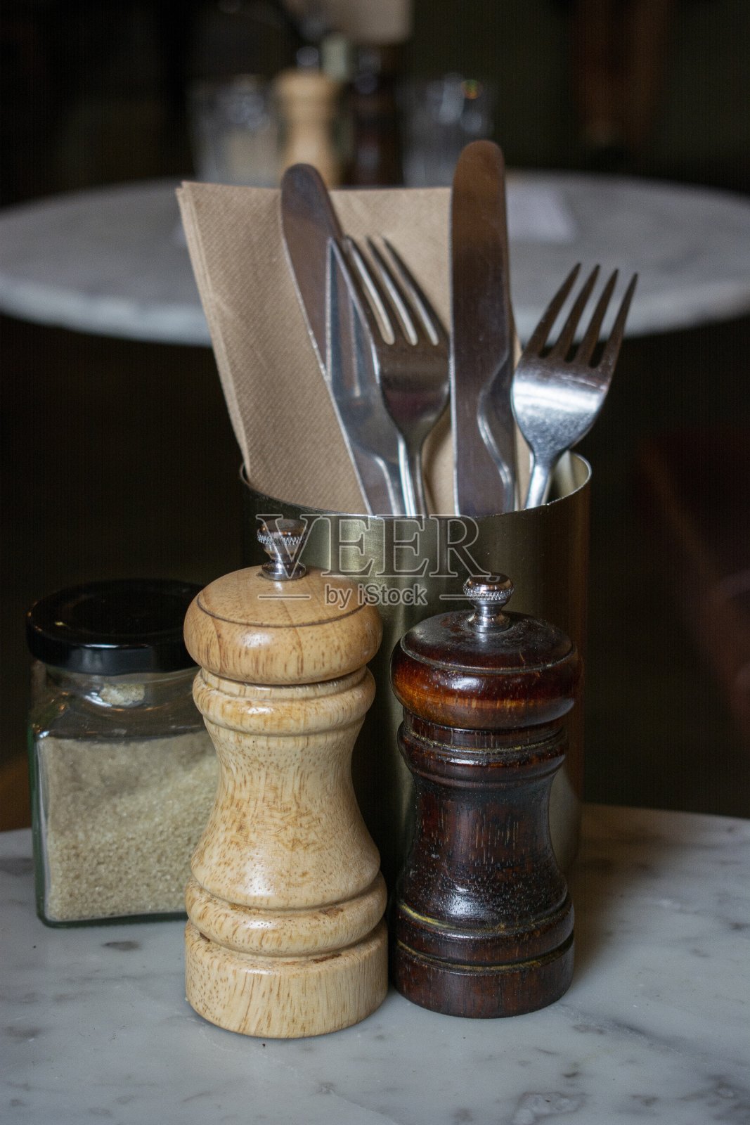 刀叉放在金属容器里,桌子上放着盐和胡椒照片摄影图片