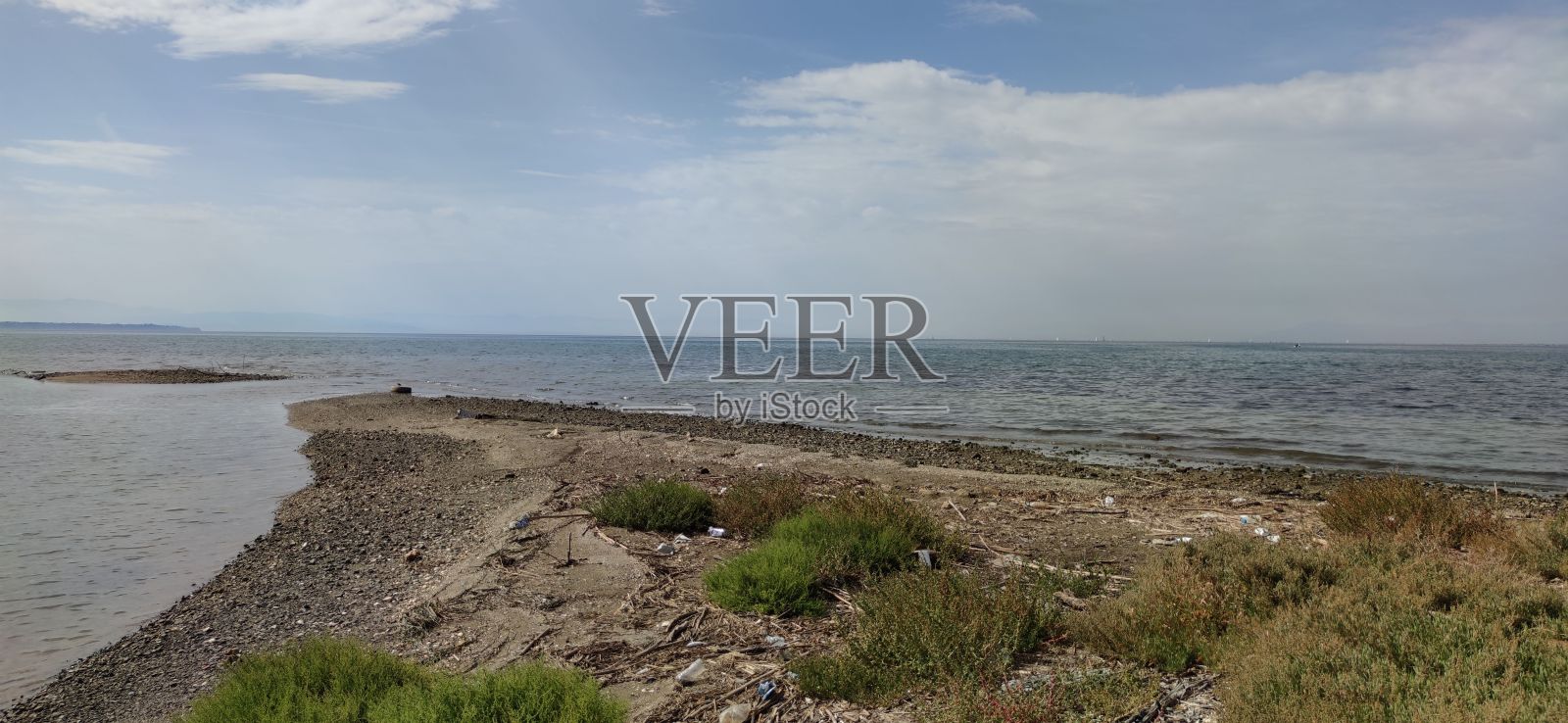 海岸的广角镜头,绿色和干燥的灌木,石头,土壤和美丽的天际线照片摄影图片