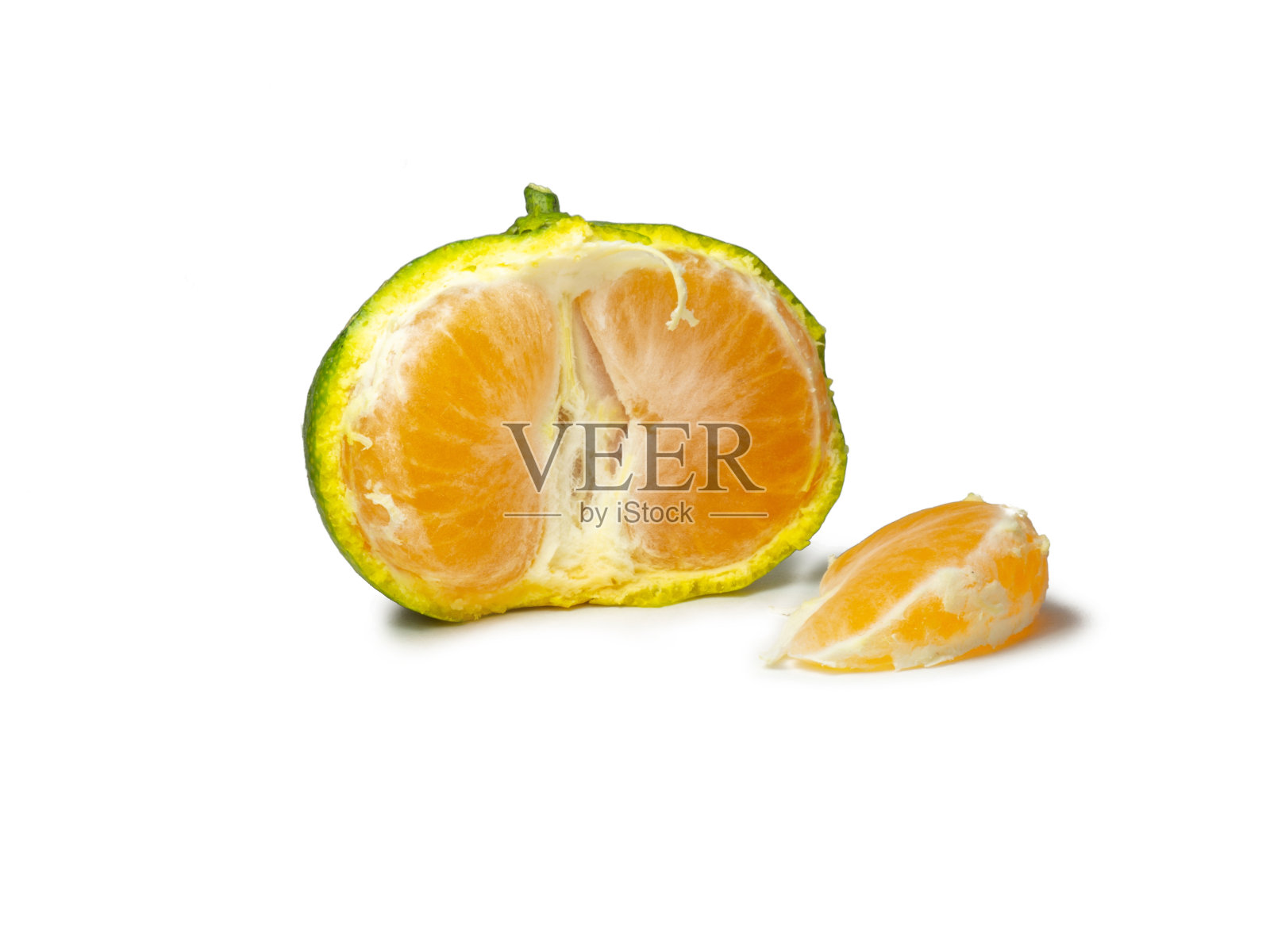 未成熟的橘子。剥一个橘子。白色背景上的绿色水果。酸成分。柑橘隔离。切片绿色普通话。照片摄影图片