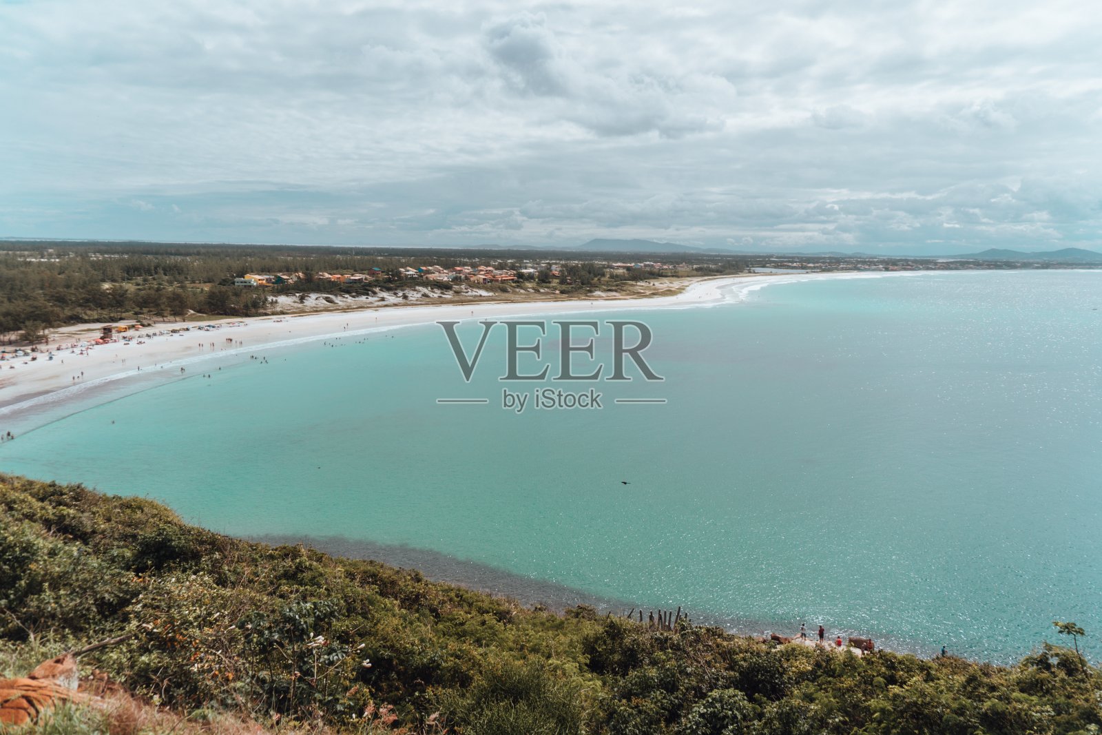 在多云的天空下,被绿色植物覆盖的岛屿包围的海洋景观照片摄影图片