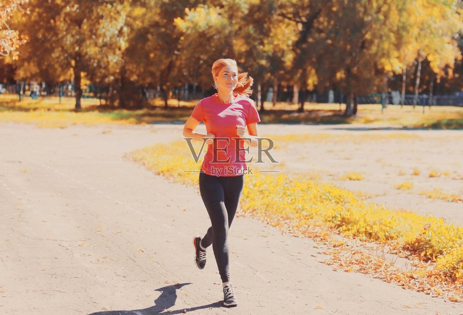 快乐微笑的年轻女子在城市公园跑步运动照片摄影图片