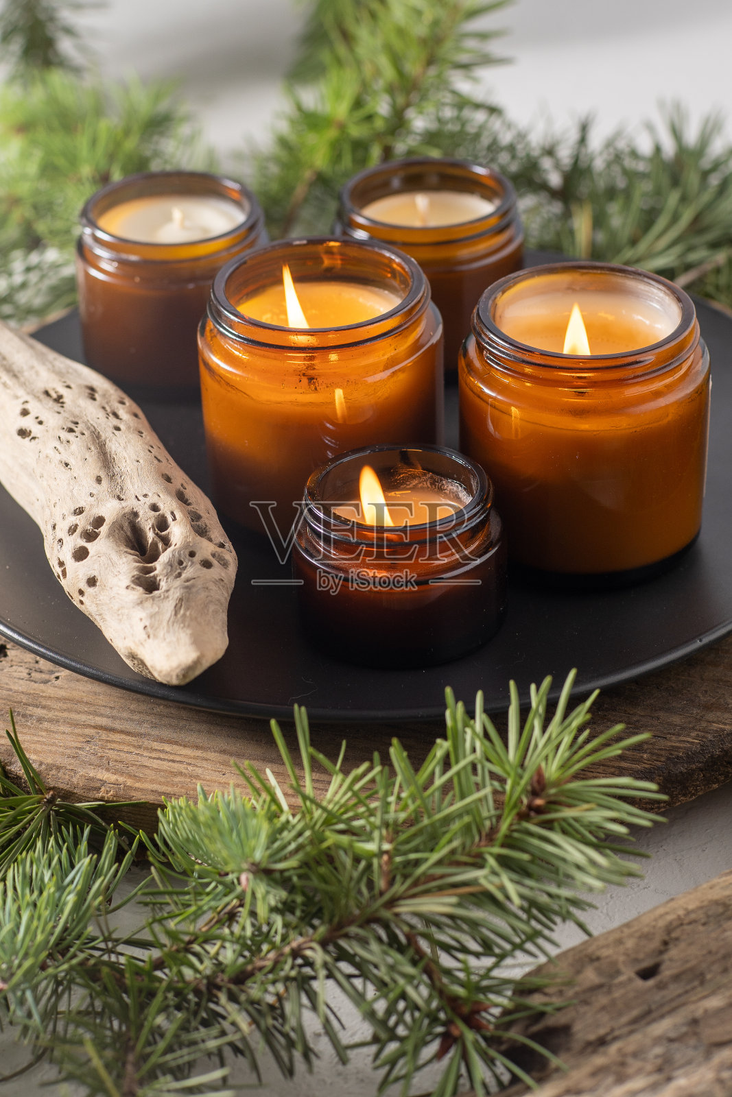 大豆蜡烛在玻璃罐中燃烧。夜晚很黑。芳香疗法和放松。家里舒适。棕色罐子里的蜡烛。光和气味。有香味的手工蜡烛。芳香疗法照片摄影图片