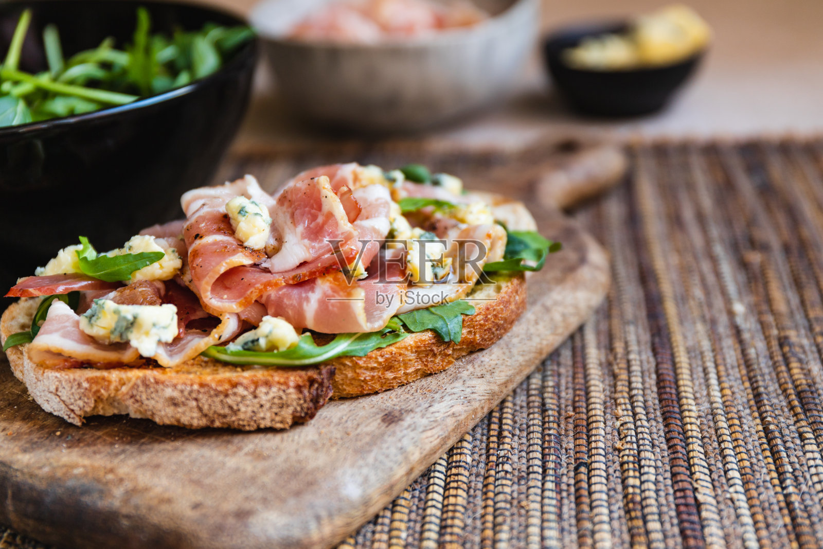 烤面包配培根,新鲜芝麻菜和蓝纹奶酪。照片摄影图片