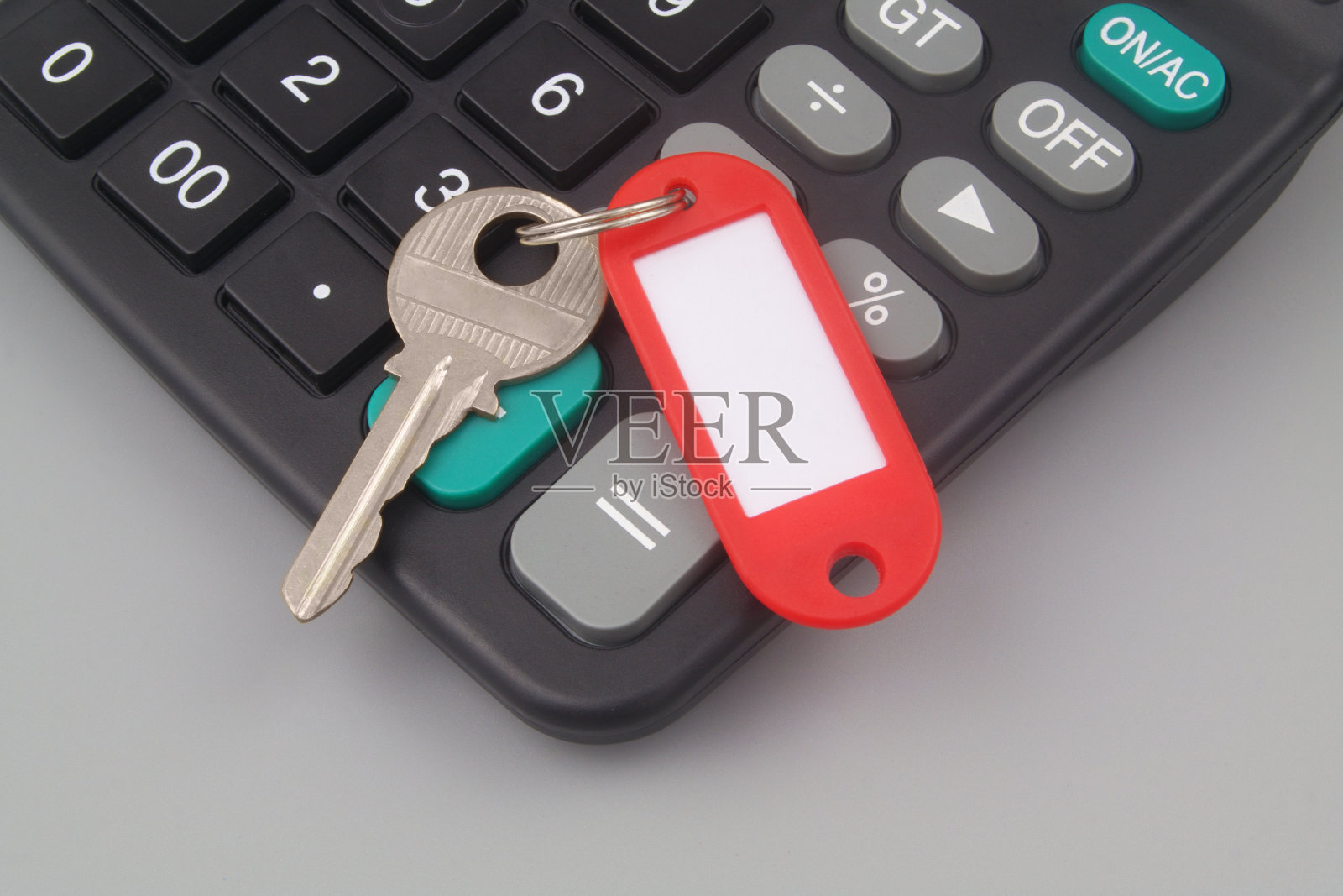 键与红色标签和计算器在灰色背景。照片摄影图片
