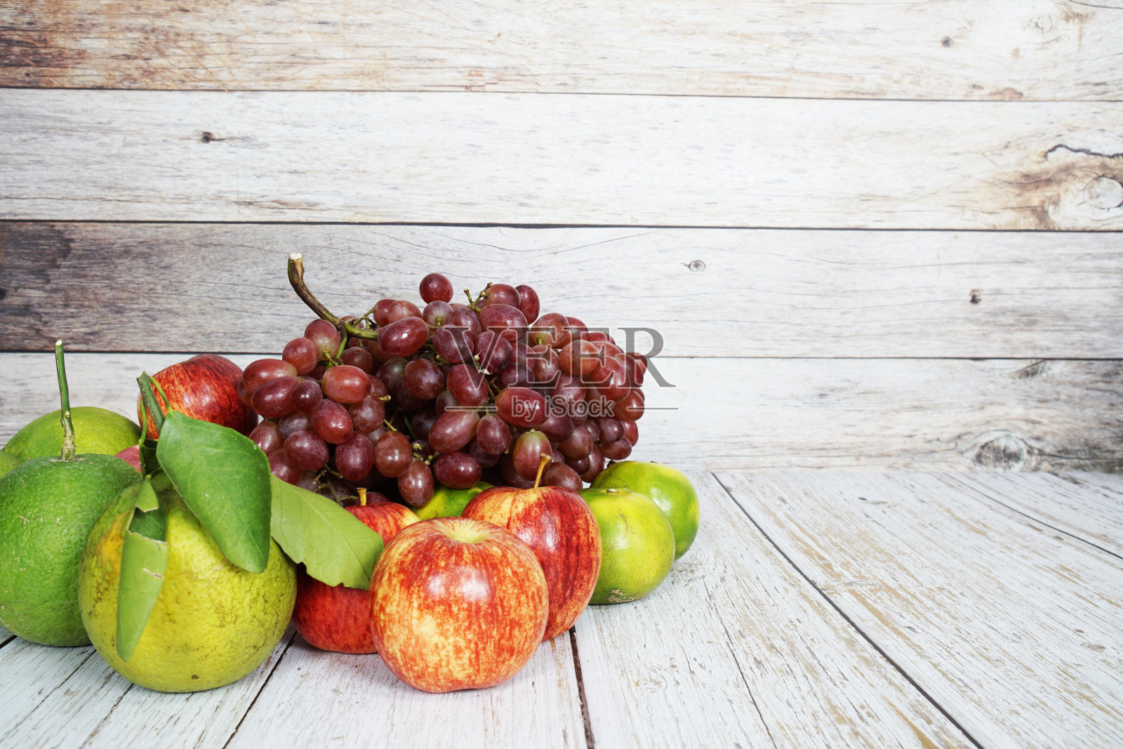 各种水果与红葡萄,红苹果和绿橙在木制背景照片摄影图片