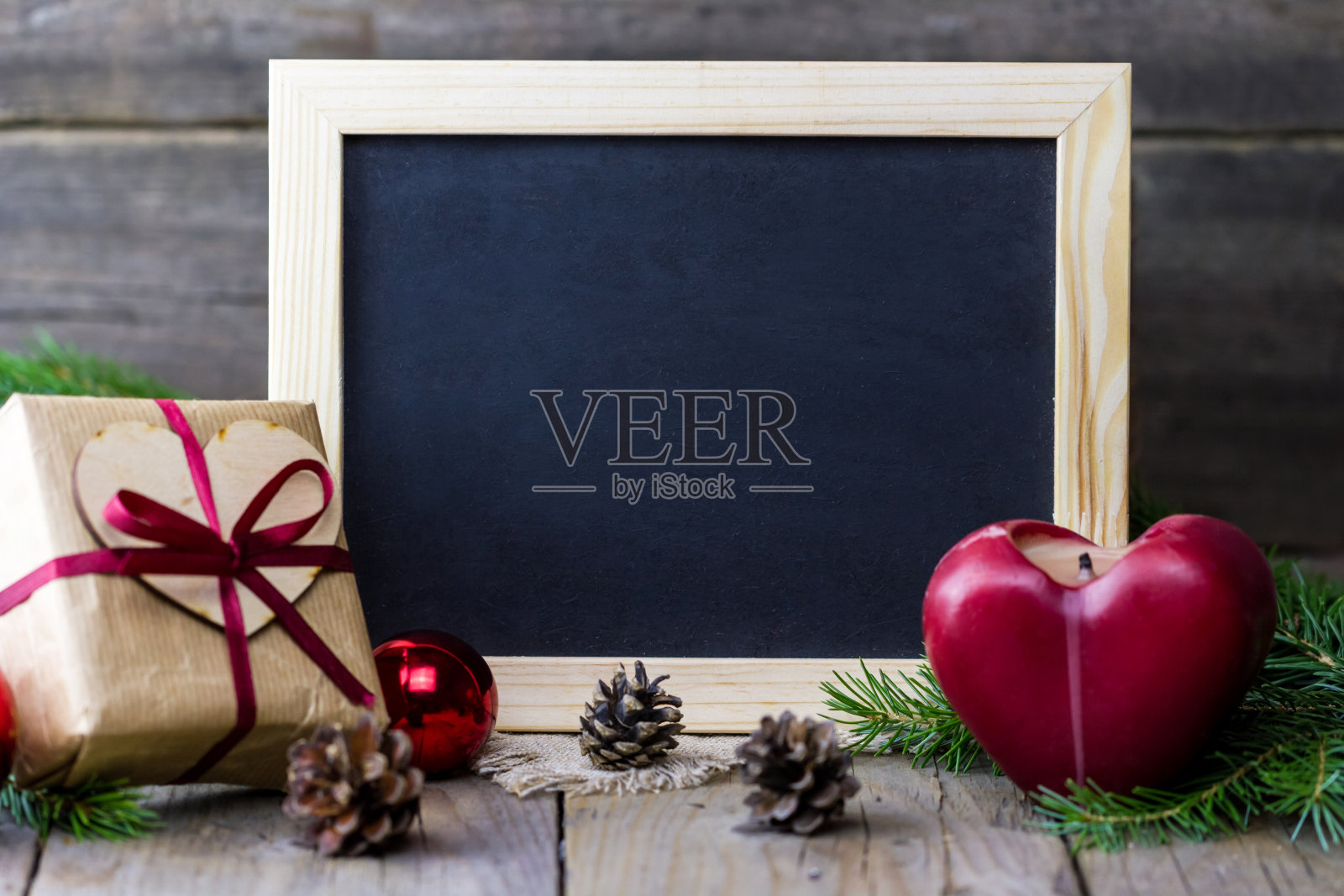 空白的黑板配上圣诞礼盒和毛皮树枝,红红的心蜡烛照片摄影图片