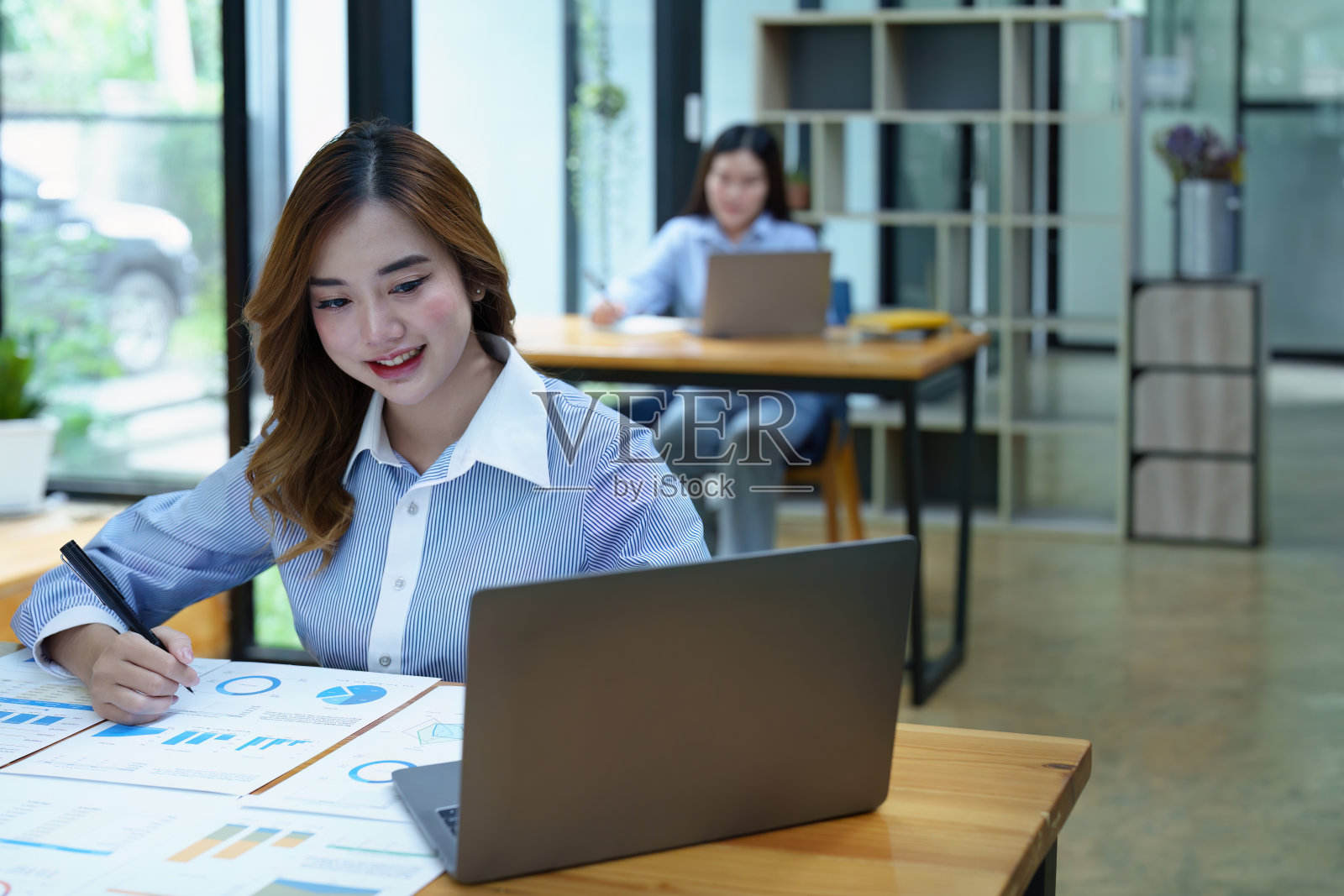 画像深思熟虑的亚洲女商人正在看财务报表和制定营销计划使用电脑在她的桌子上照片摄影图片