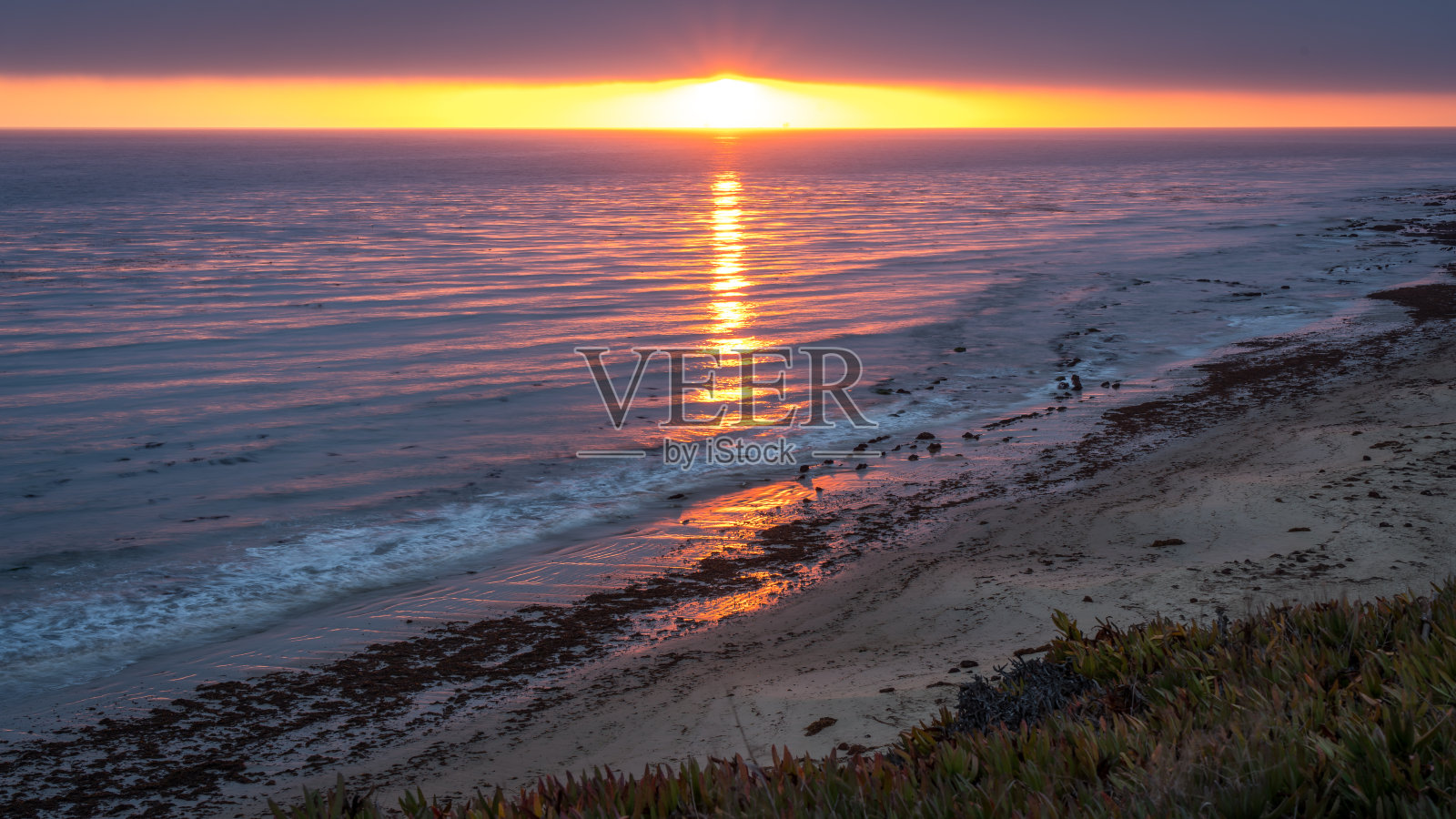海滩日落与紫色和粉色照明照片摄影图片