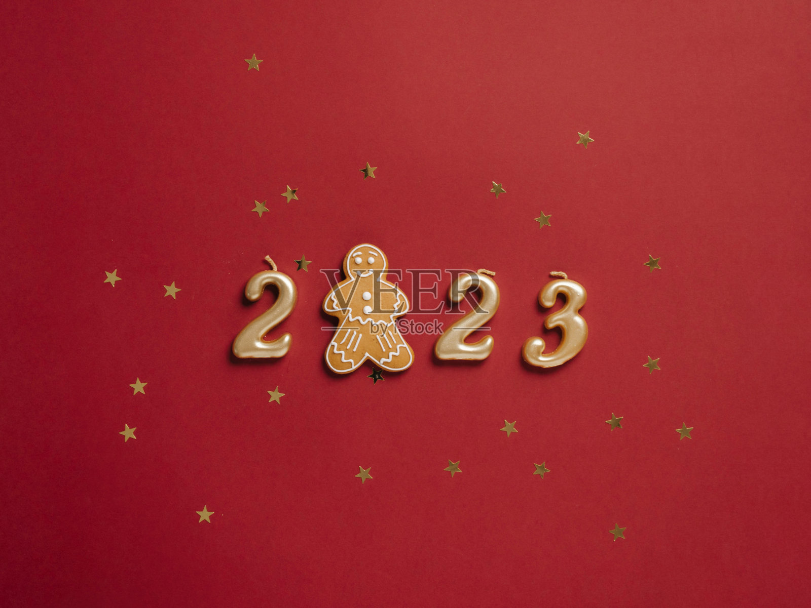 2023年的新年日期和姜饼人饼干红色节日背景与五彩纸屑闪闪发光照片摄影图片