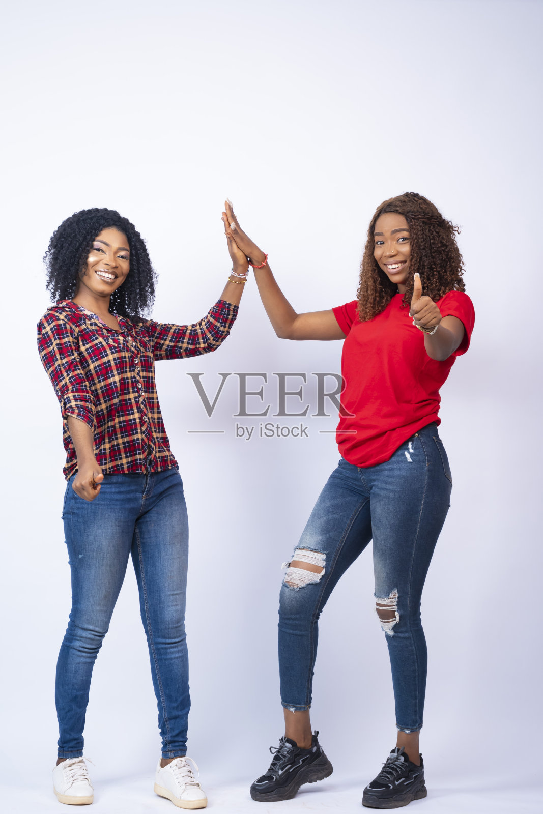 两个漂亮的非洲女性互相击掌的垂直镜头照片摄影图片