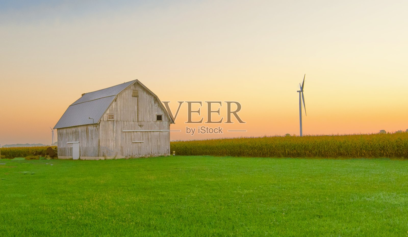 旧风化谷仓与风车和玉米田日出-蒂普顿县,印第安纳州照片摄影图片