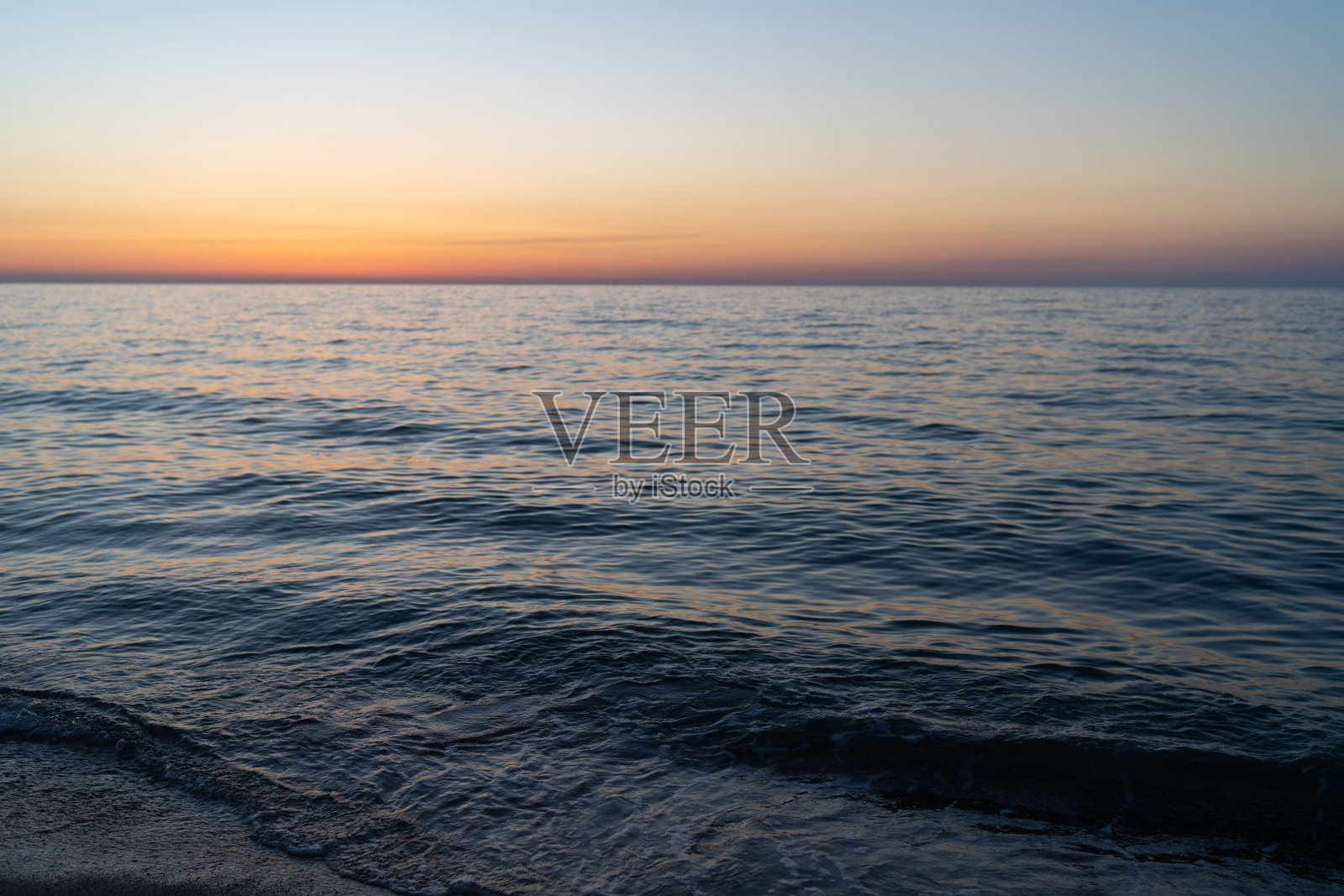 日落的天空倒映在水中,从沙滩上鸟瞰。旅游目的地,度假概念。假期假期旗帜。冥想海洋和全景海滩景观照片摄影图片