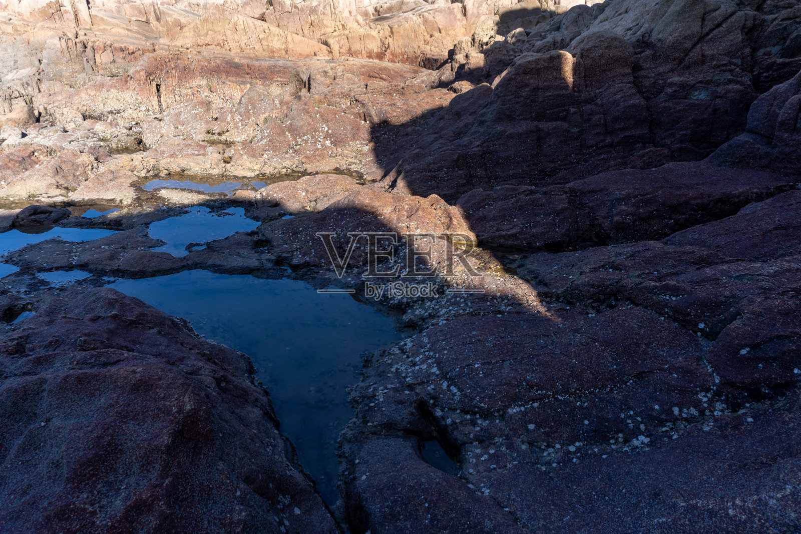 阳光照射在海边石头上产生的光影照片摄影图片