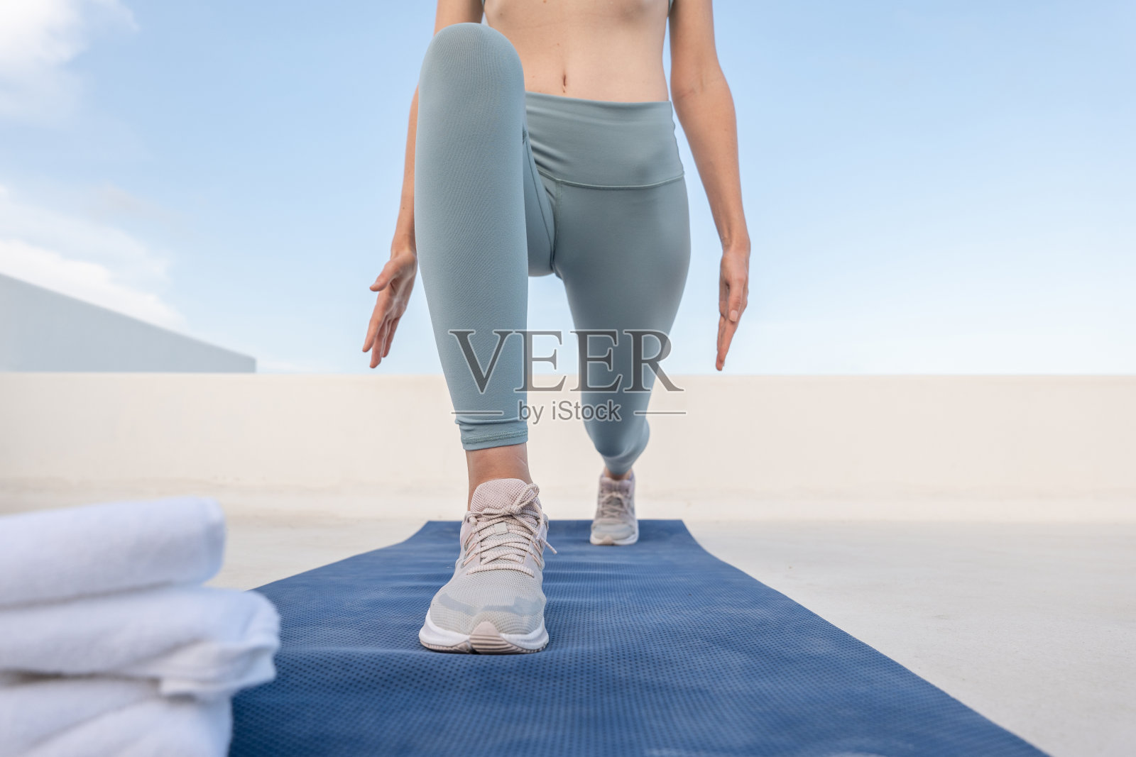 年轻女子在日落时在屋顶健身,弓步照片摄影图片