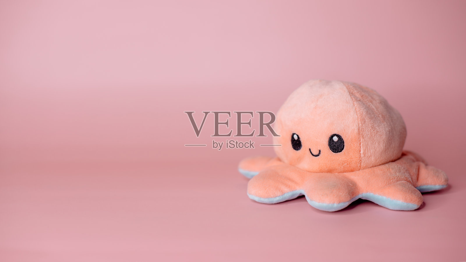 粉色背景上的粉色章鱼玩具照片摄影图片