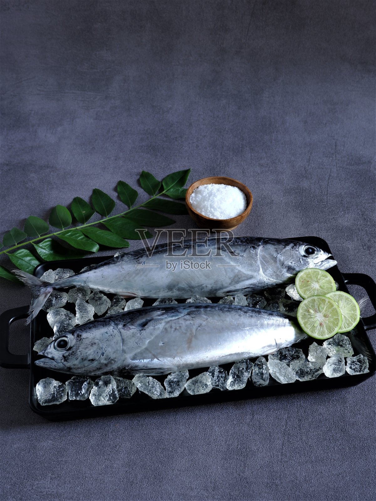 黑色方形托盘上的新鲜小金枪鱼照片摄影图片