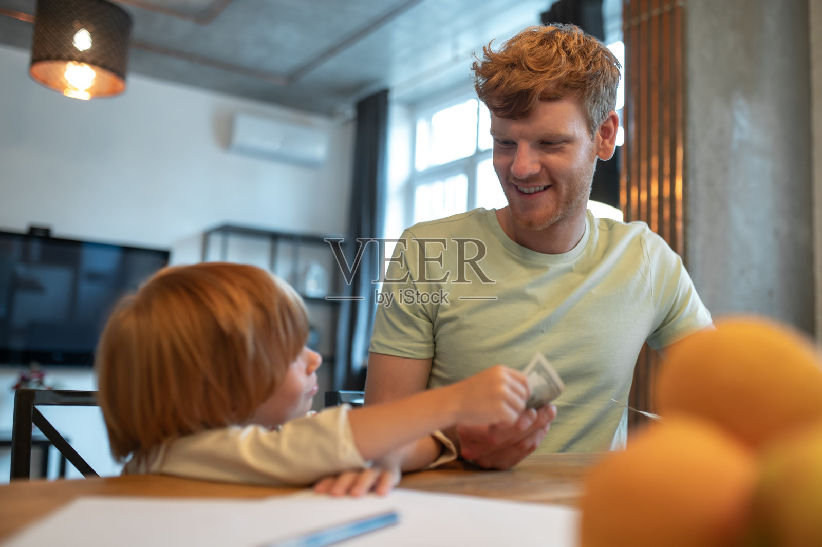 爸爸正在教小儿子金融基础知识照片摄影图片