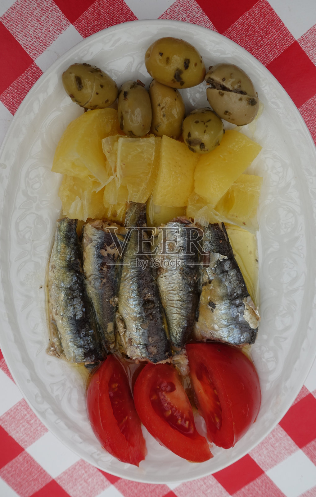 沙丁鱼罐头柠檬油封番茄和青橄榄开胃照片摄影图片