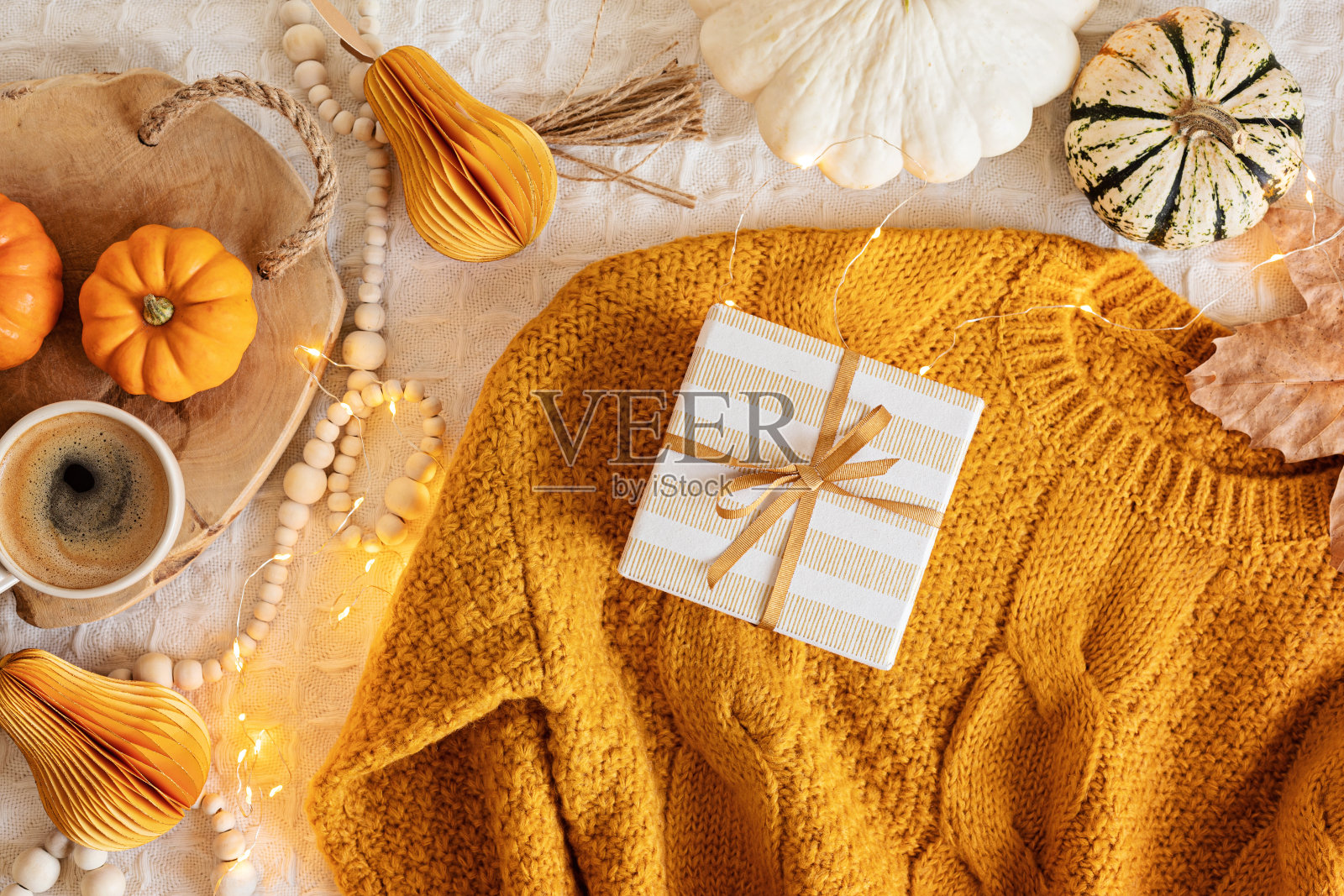 秋日平铺构图。温暖舒适的毛衣,南瓜,礼品盒,干树叶。感恩,秋天,慢生活的概念。俯视图,复制空间照片摄影图片