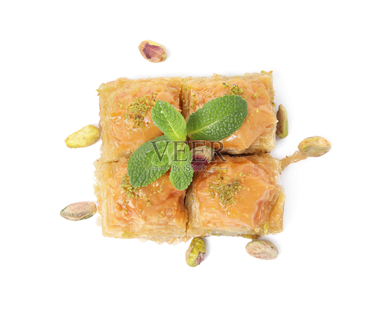 美味的果仁蜜饼与开心果,薄荷和分散的坚果在白色背景,俯视图照片摄影图片