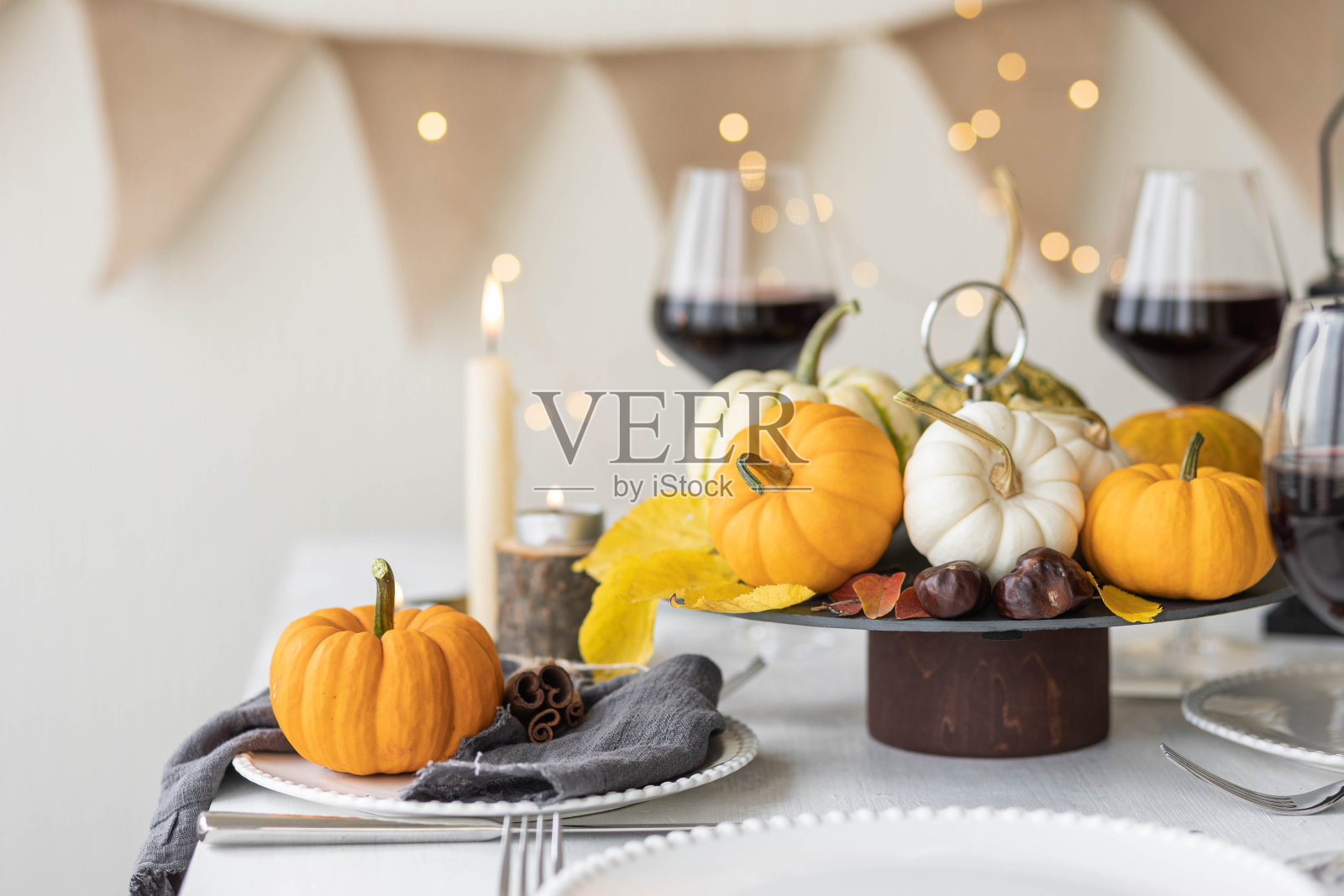 为感恩节家庭晚餐或婚礼设计一个美丽的秋天环境。橙色南瓜装饰。舒适的秋季家庭氛围。照片摄影图片