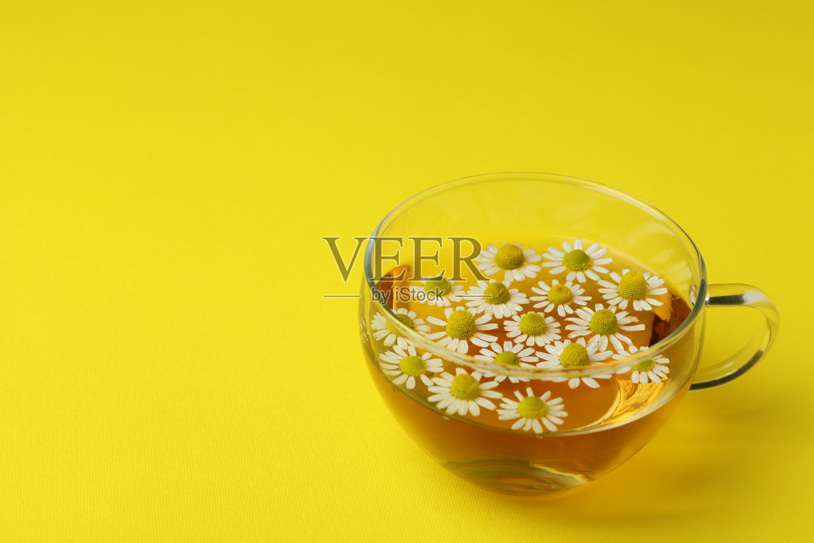 一杯黄色背景的洋甘菊茶照片摄影图片