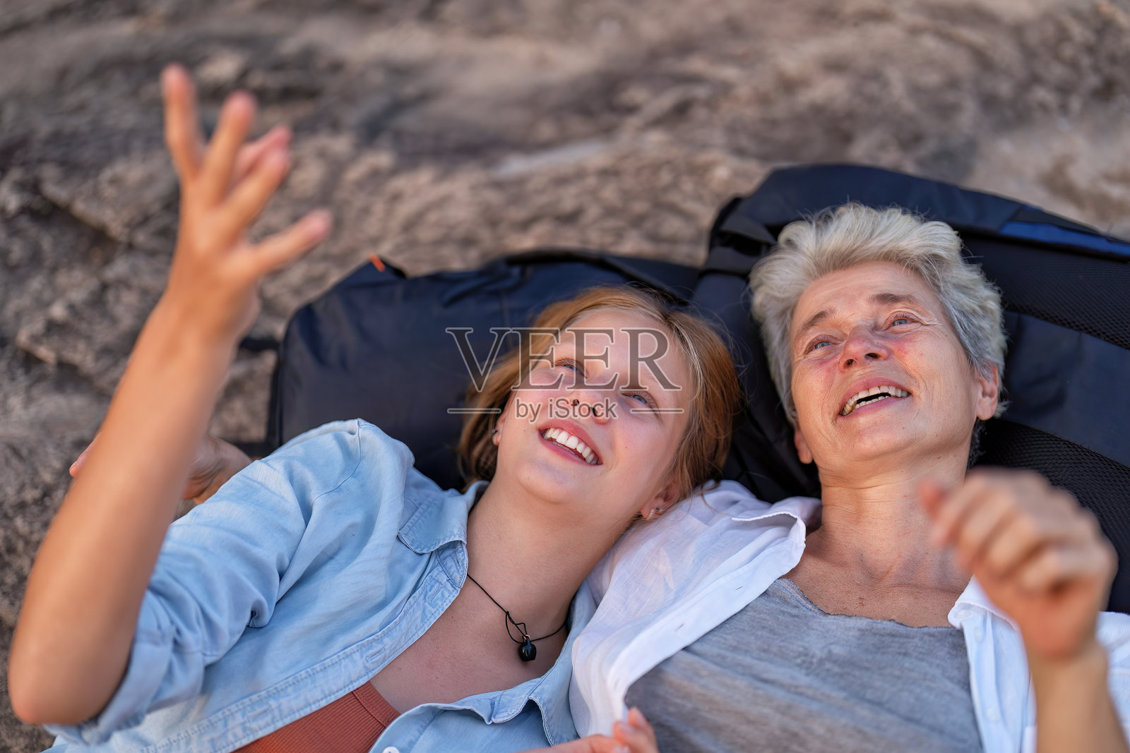 双肩包冒险徒步旅行者母女躺在山上微笑望着天空照片摄影图片