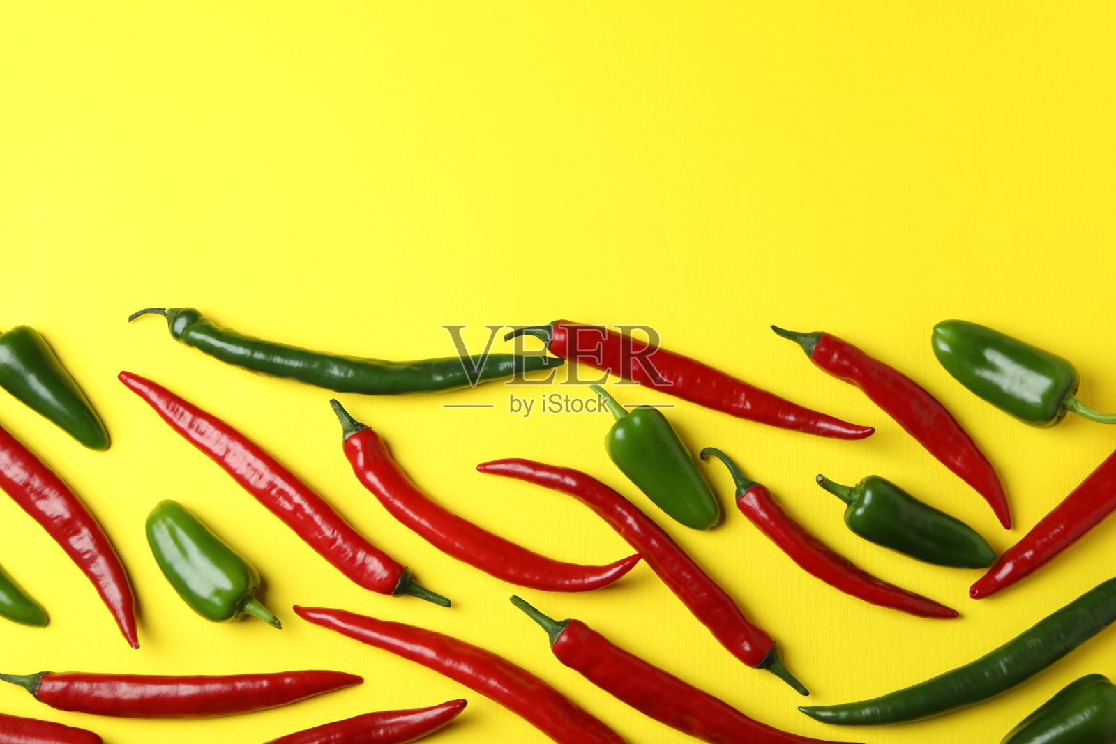 黄色背景上红绿相间的辣椒照片摄影图片