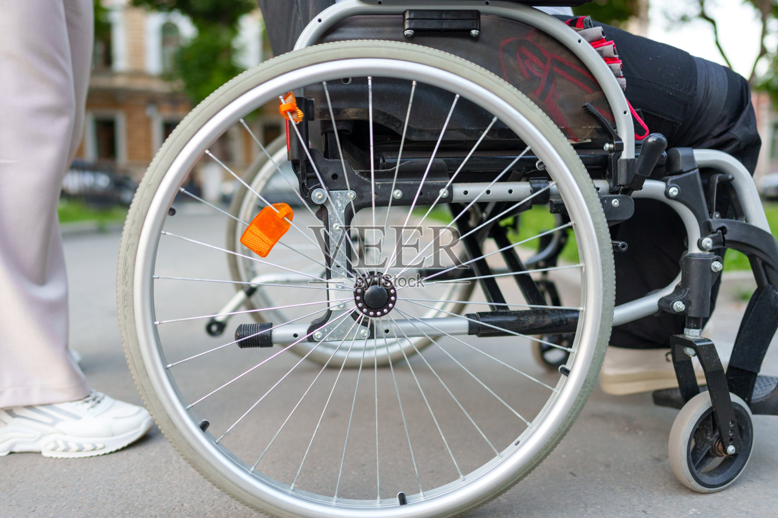 无法辨认的残疾妇女坐在轮椅上在街道上近距离照片摄影图片