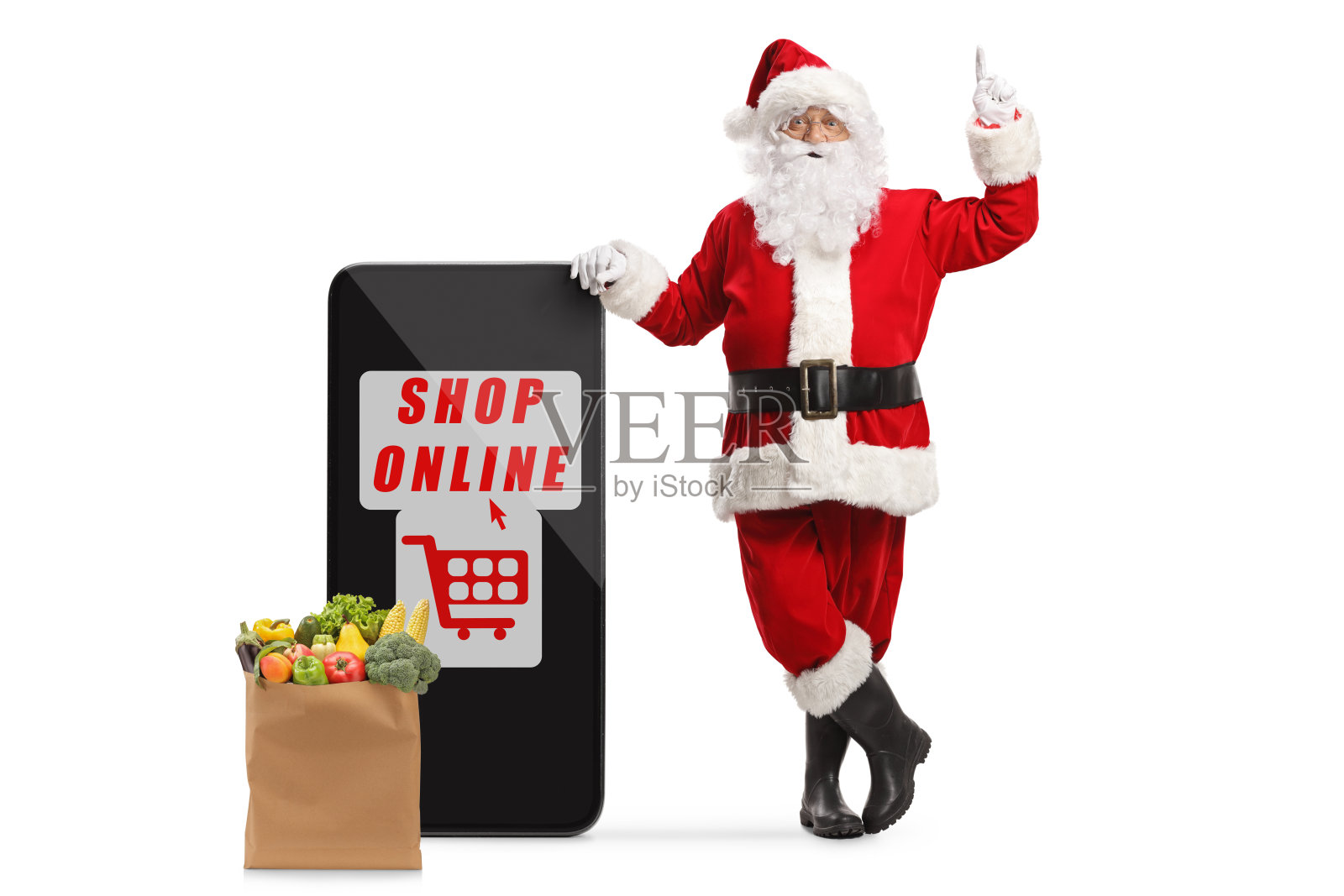 圣诞老人靠在一个大大的手机上,用文字在网上购物,指着上面照片摄影图片
