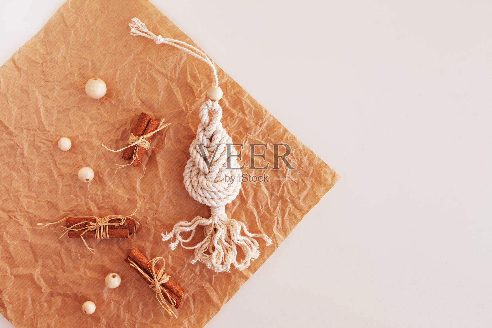 圣诞流苏装饰。木板上的圣诞玩具。天然材料-棉线,木珠和木棒。生态装饰,装饰品,手工装饰。冬季和新年假期。照片摄影图片