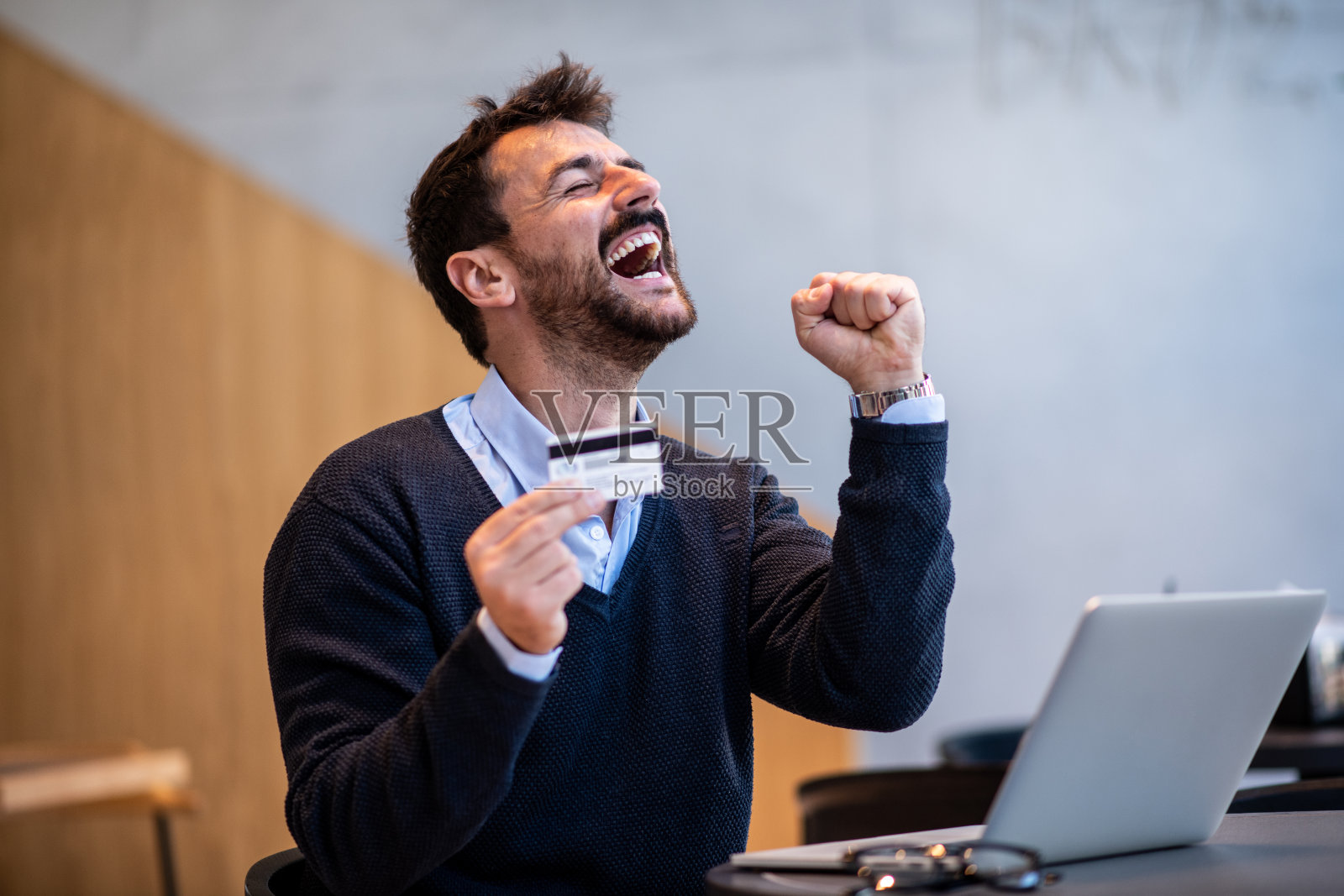 年轻人在网上购物时庆祝获得了很大的折扣照片摄影图片
