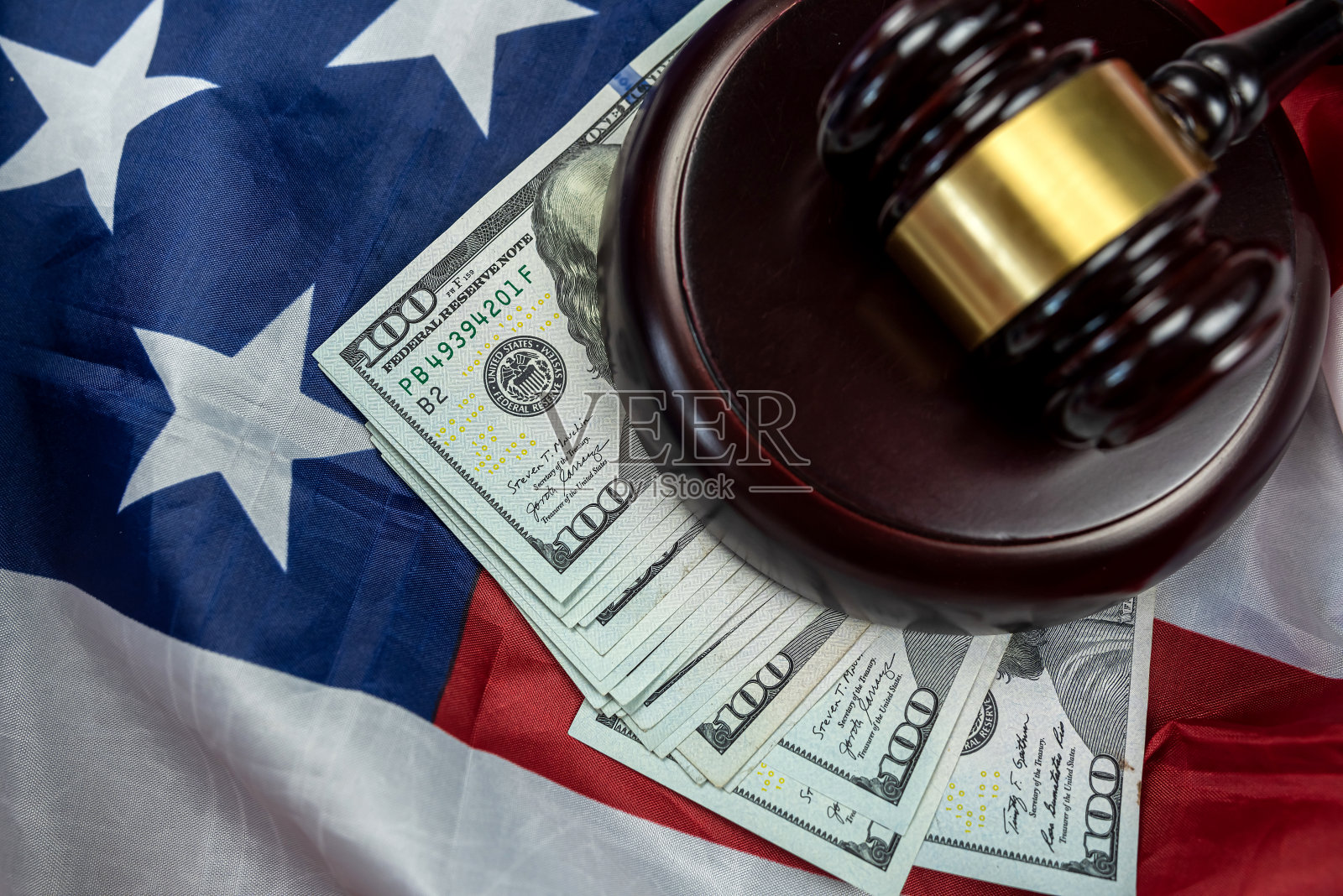 百元美钞与法官 gavel 置于美国国旗之上照片摄影图片