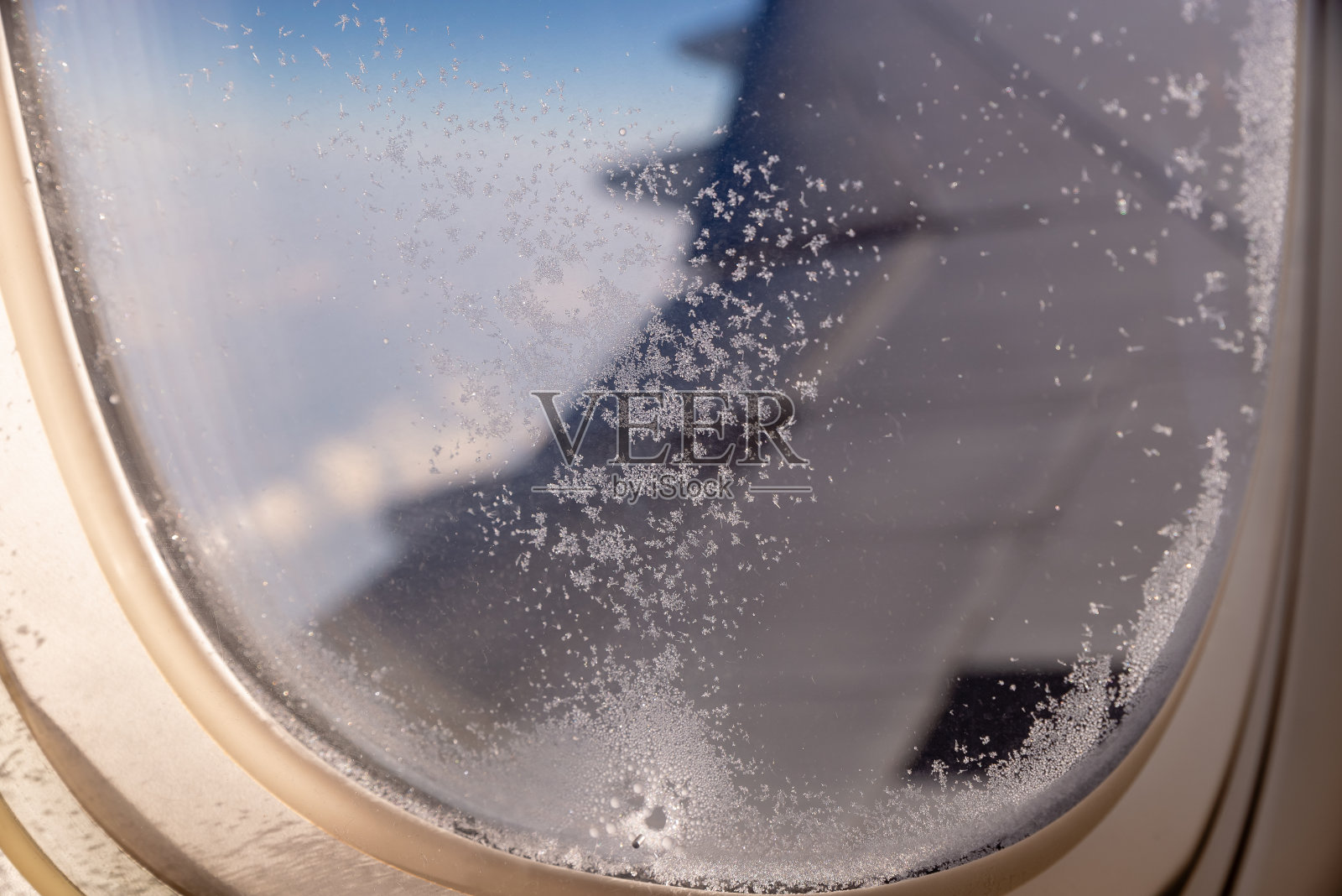 在飞行过程中,飞机窗户上结冰的玻璃照片摄影图片