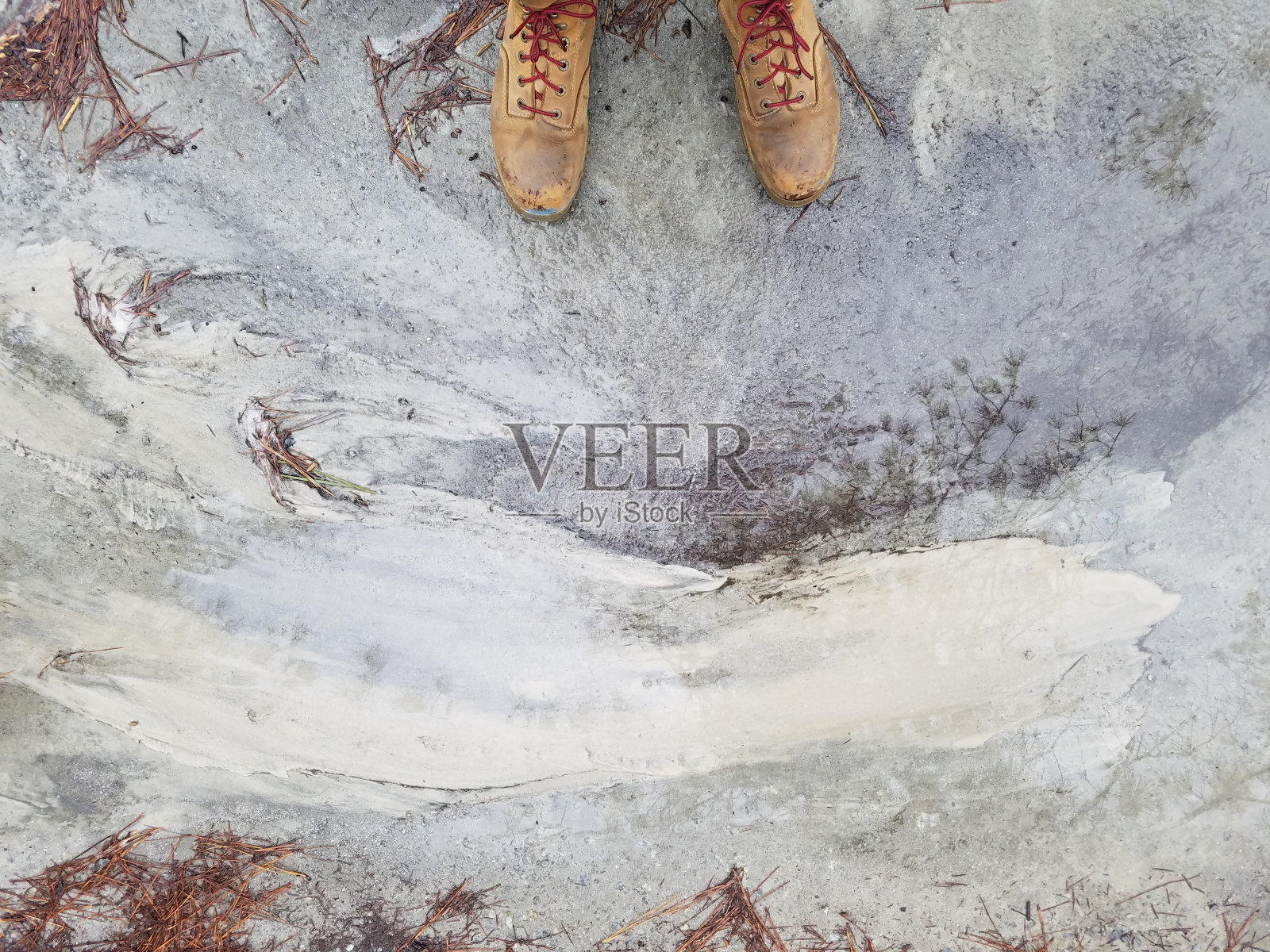 人们穿着棕色皮鞋,站在饱经风霜的水泥地上照片摄影图片