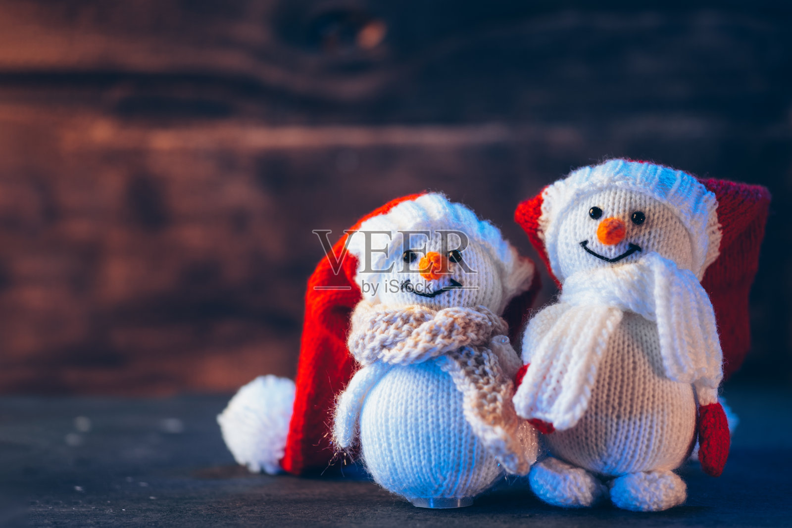 木桌上有一对可爱的雪人。复制空间假期卡照片摄影图片