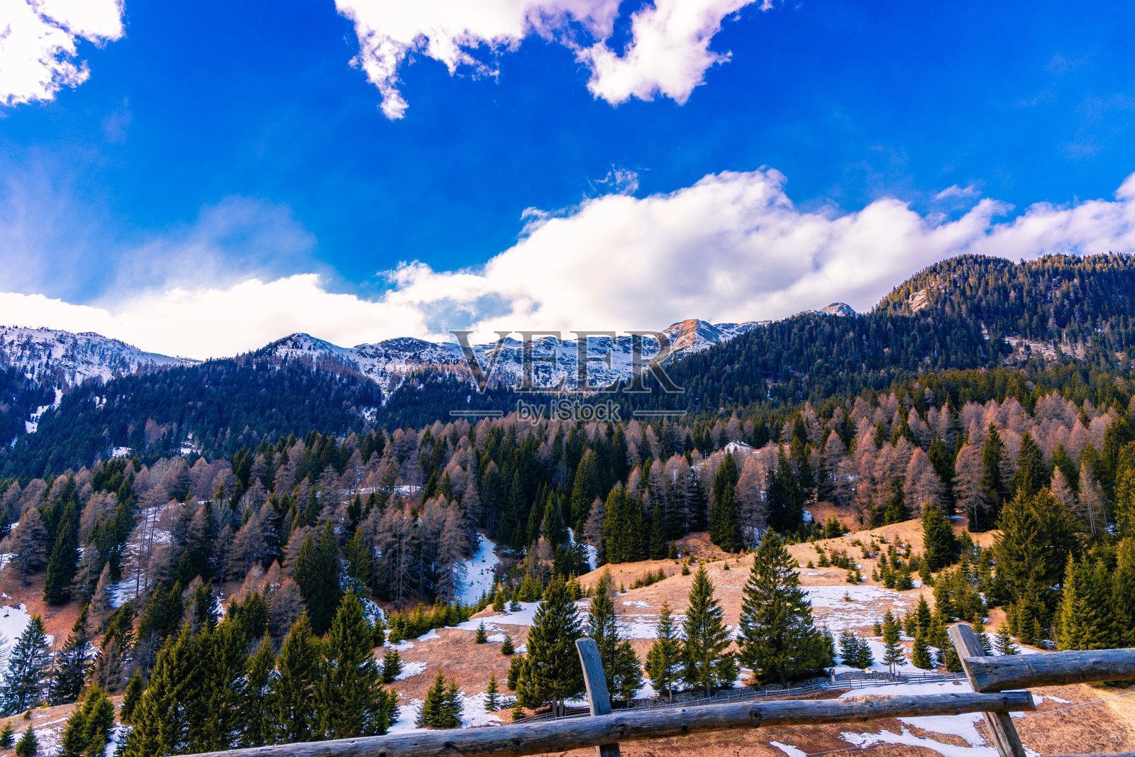 高角度拍摄了一个美丽的森林,被白雪覆盖的高山包围照片摄影图片