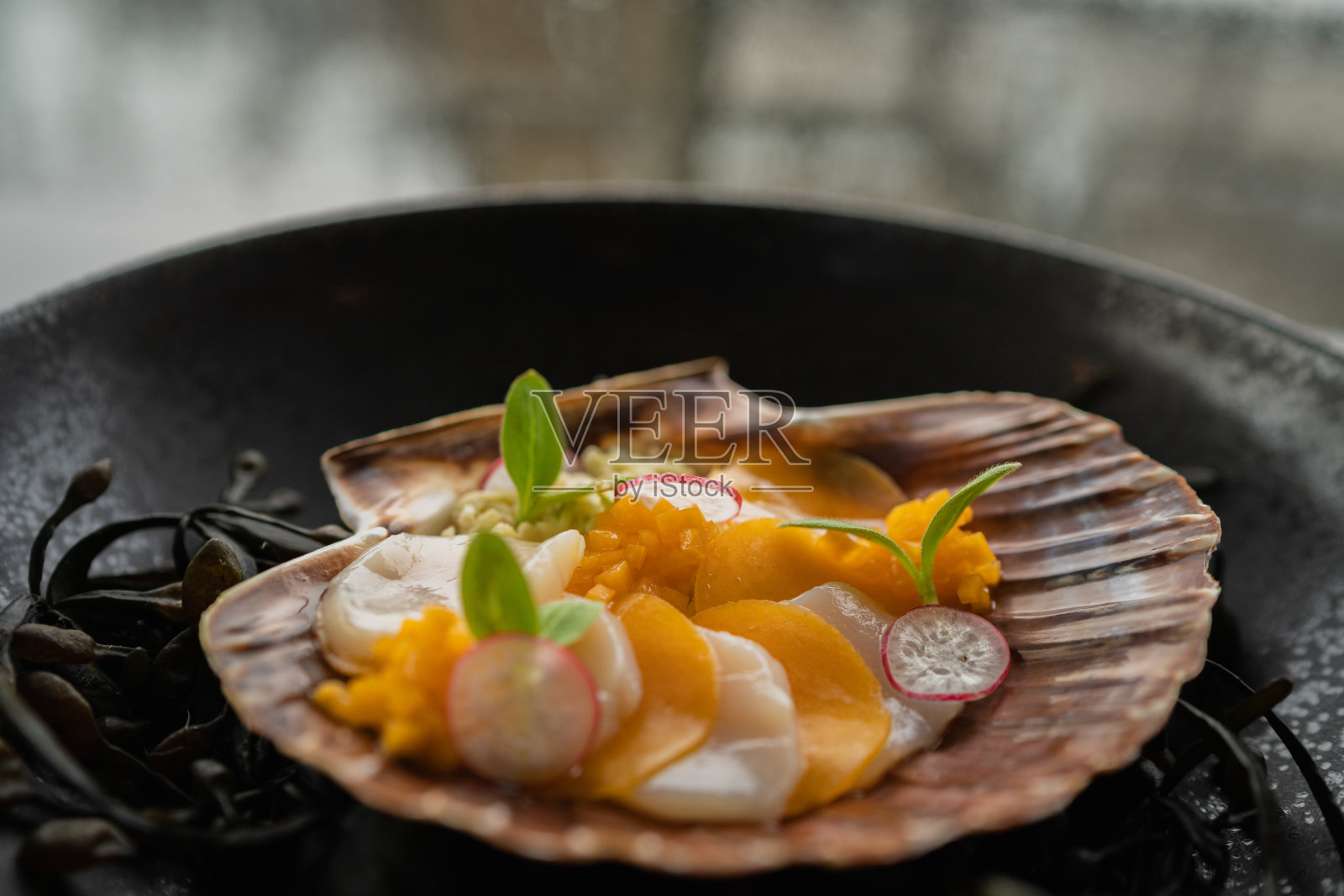 在深色盘子里的美味的圣雅克的特写照片摄影图片