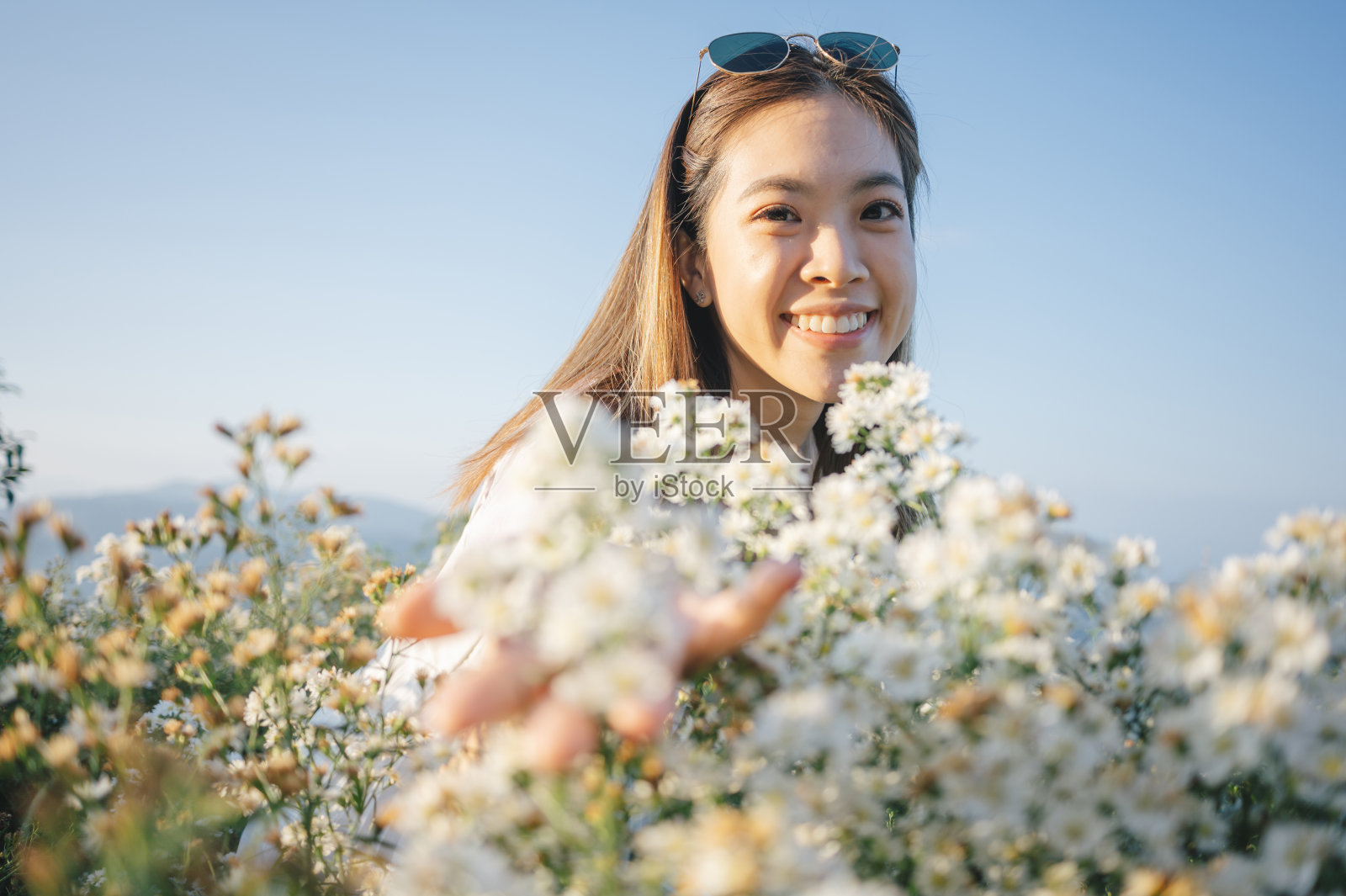 一位迷人的泰国/中国女性兴奋快乐地捕捉完美的日落时刻,她的追随者照片摄影图片